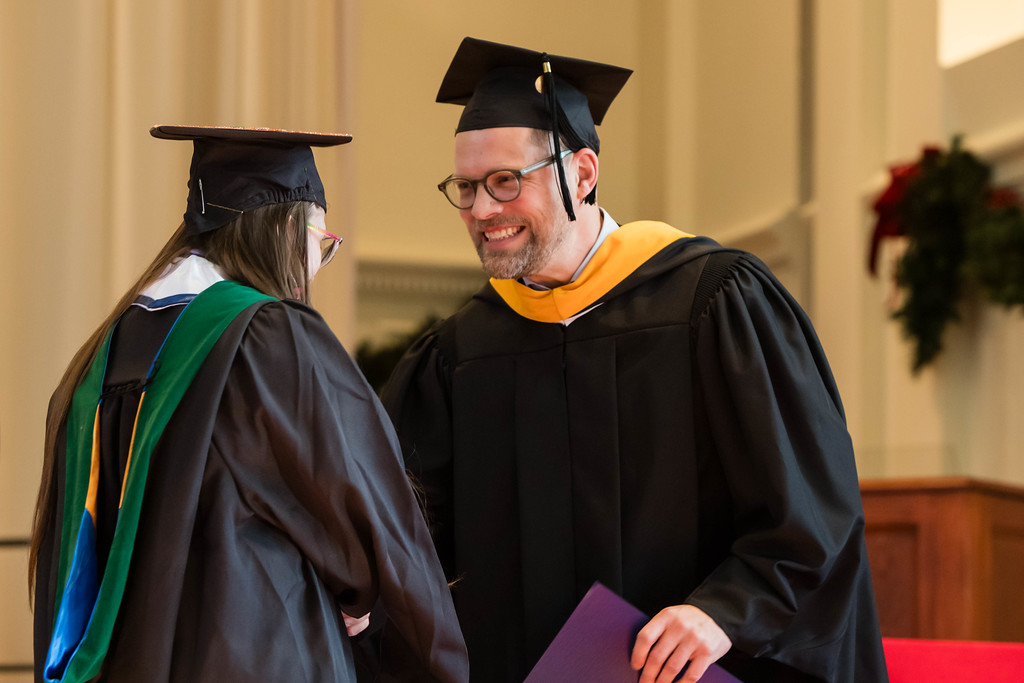 two individuals on a graduation stage