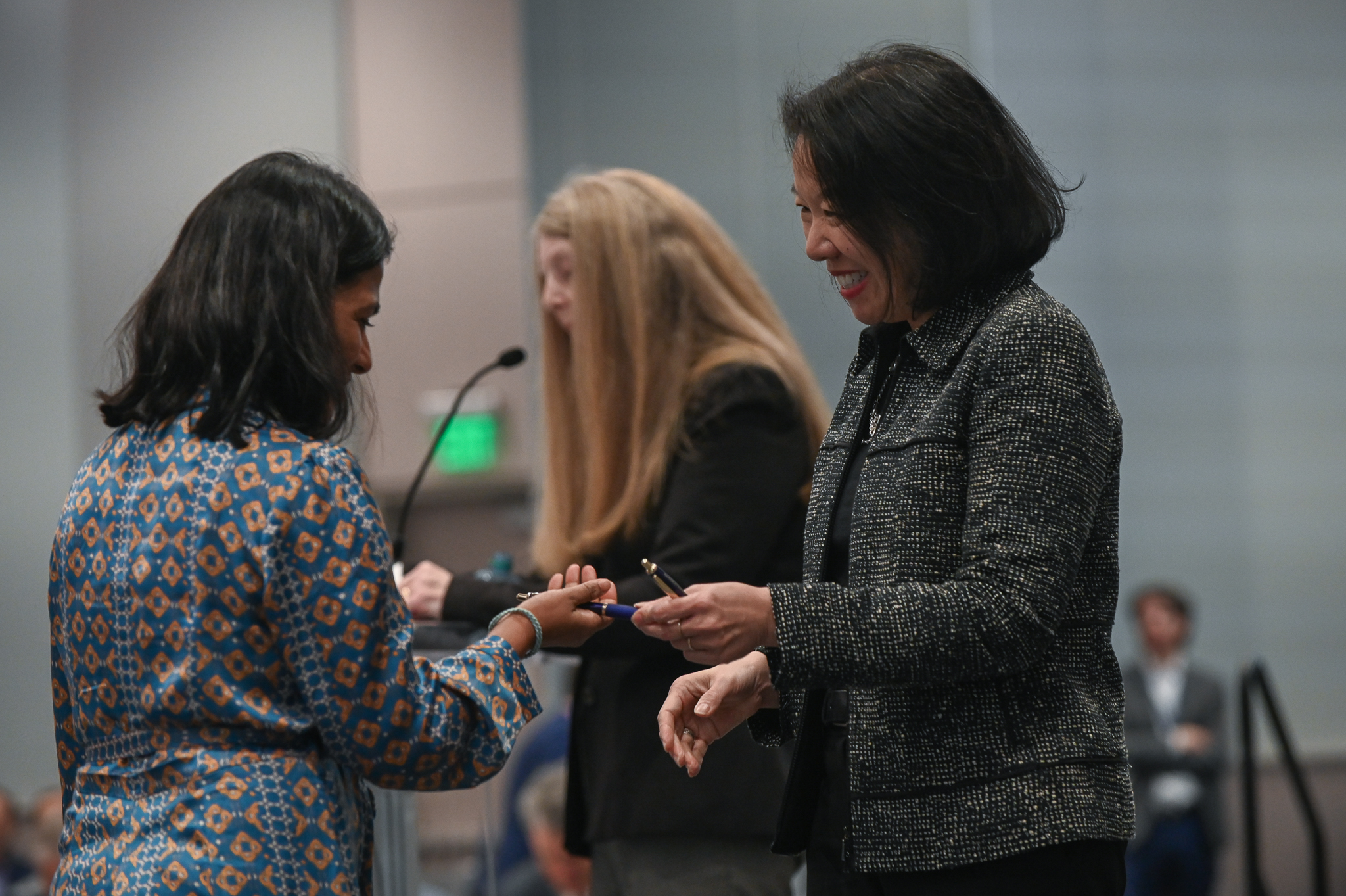Woman accepts award on stage from dean