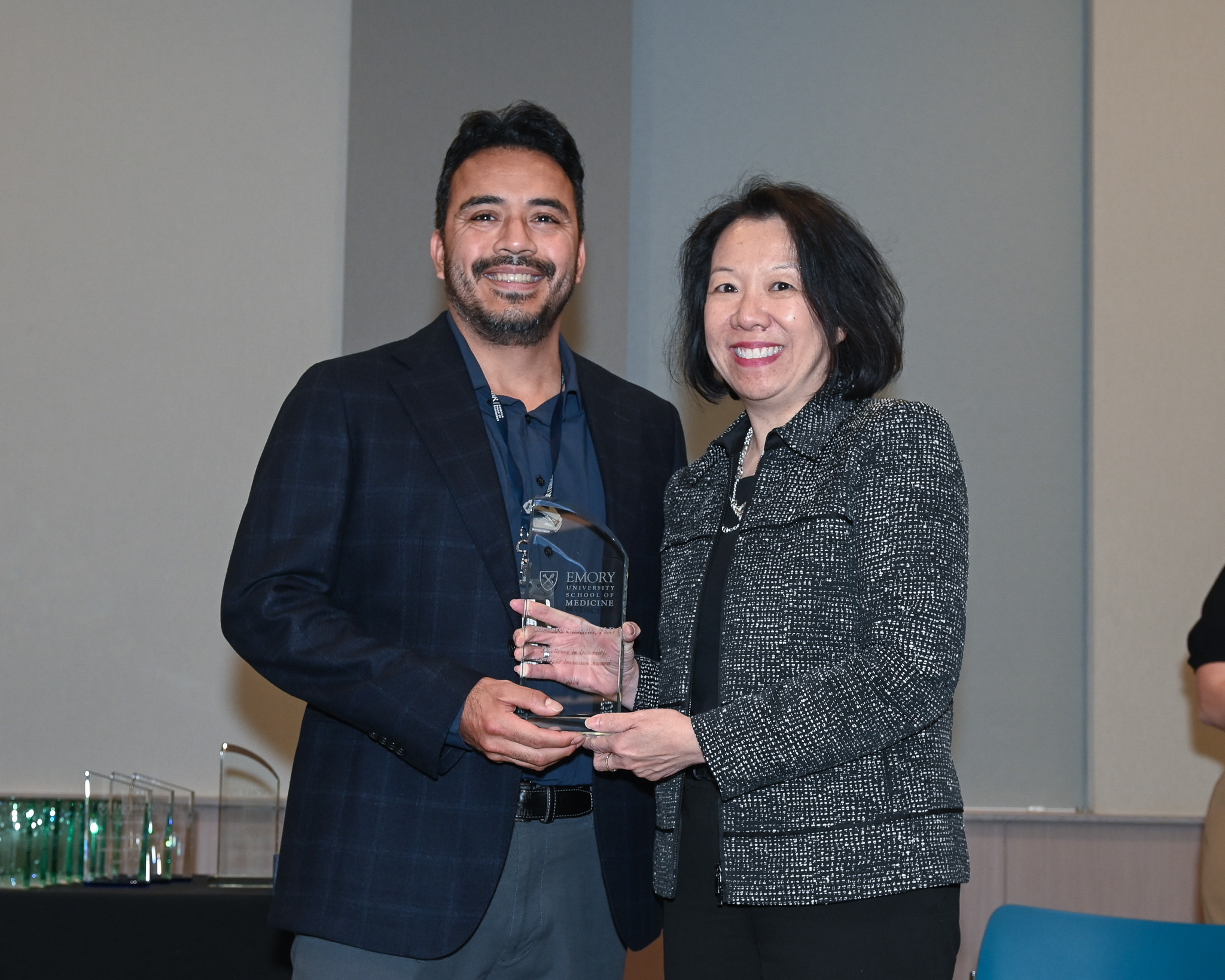 Faculty member accepts glass award on stage with dean