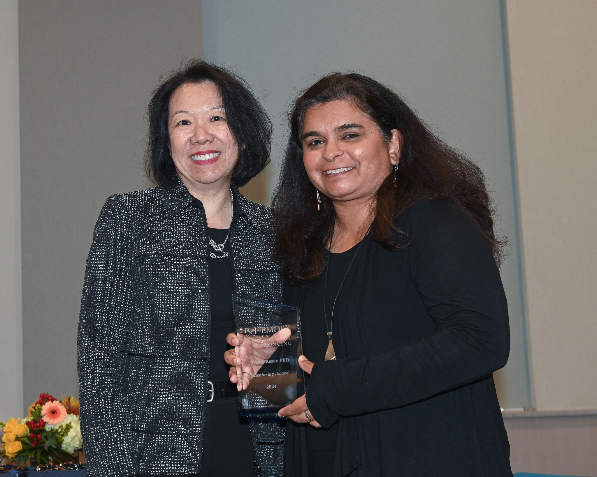 Faculty member accepts glass award on stage with dean