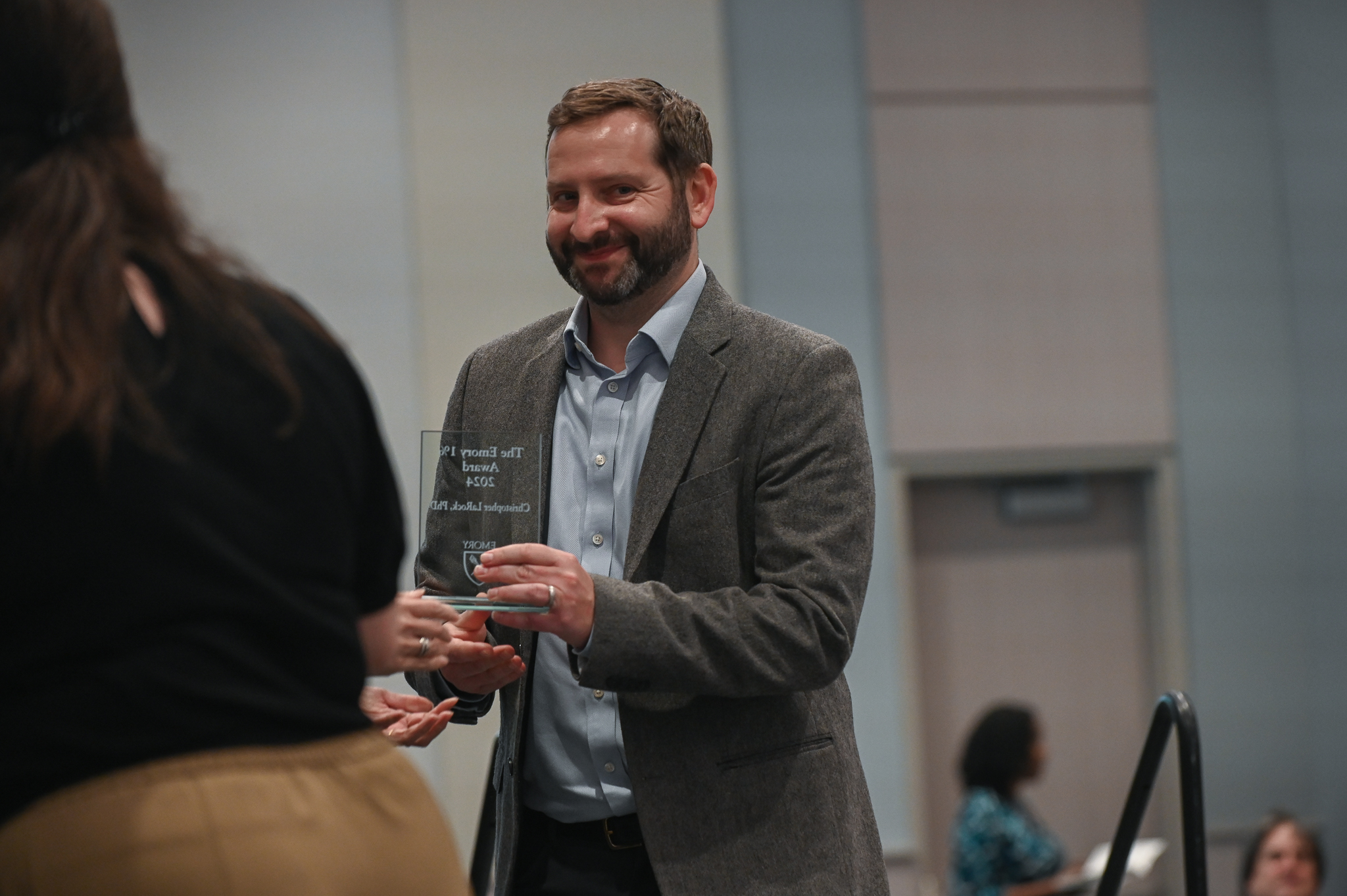 Faculty member accepts glass award on stage