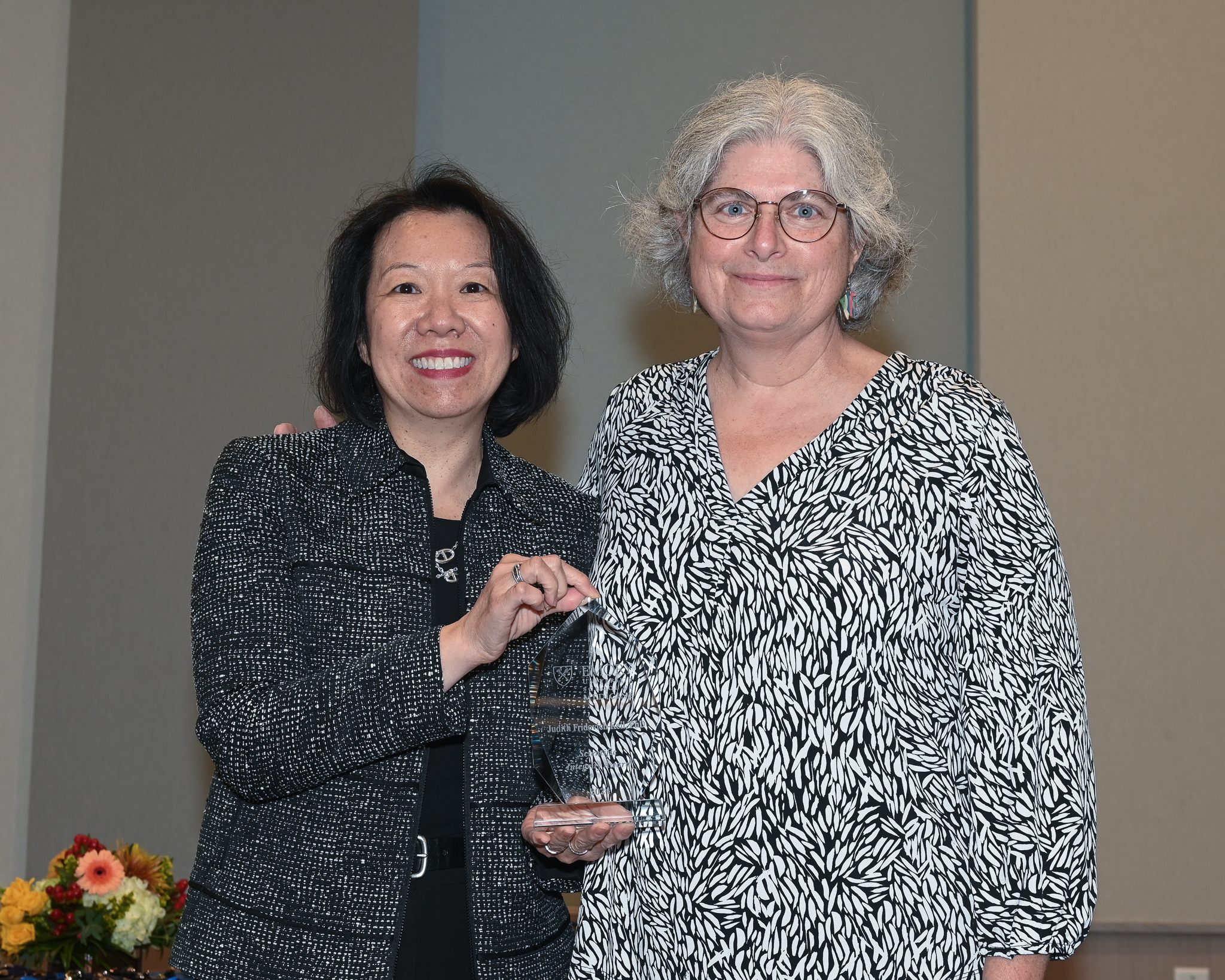 Faculty member accepts glass award on stage with dean