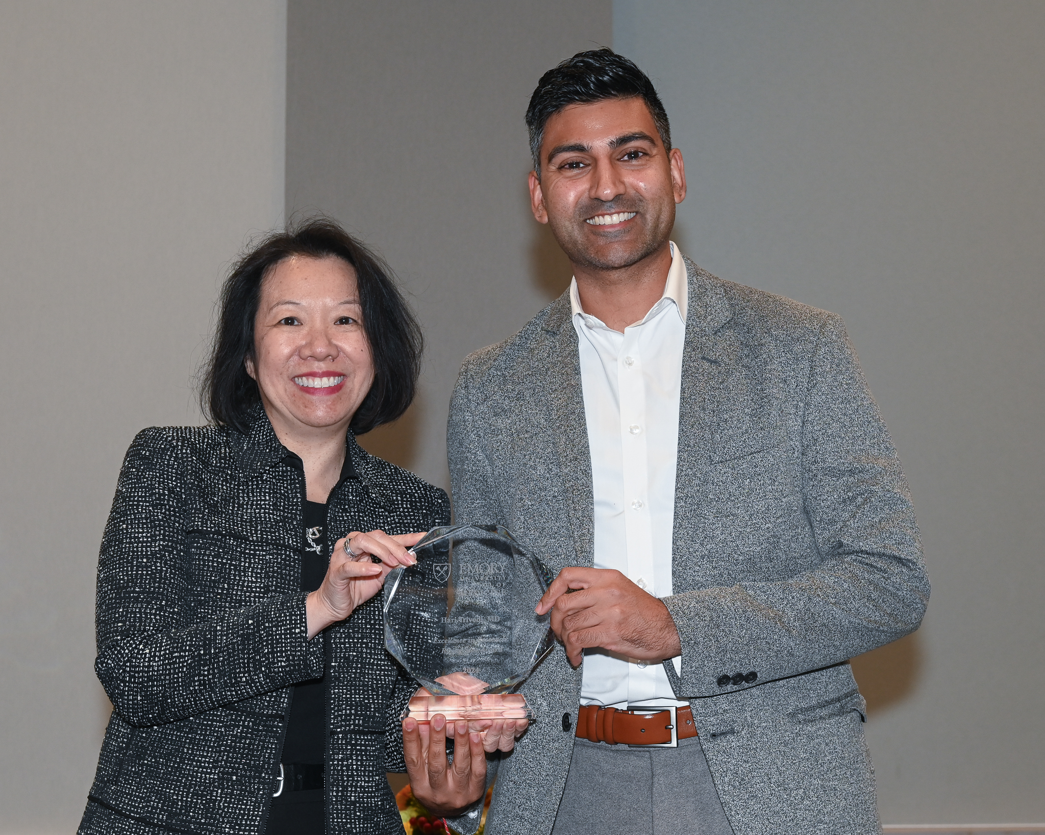 Faculty member accepts glass award on stage with dean