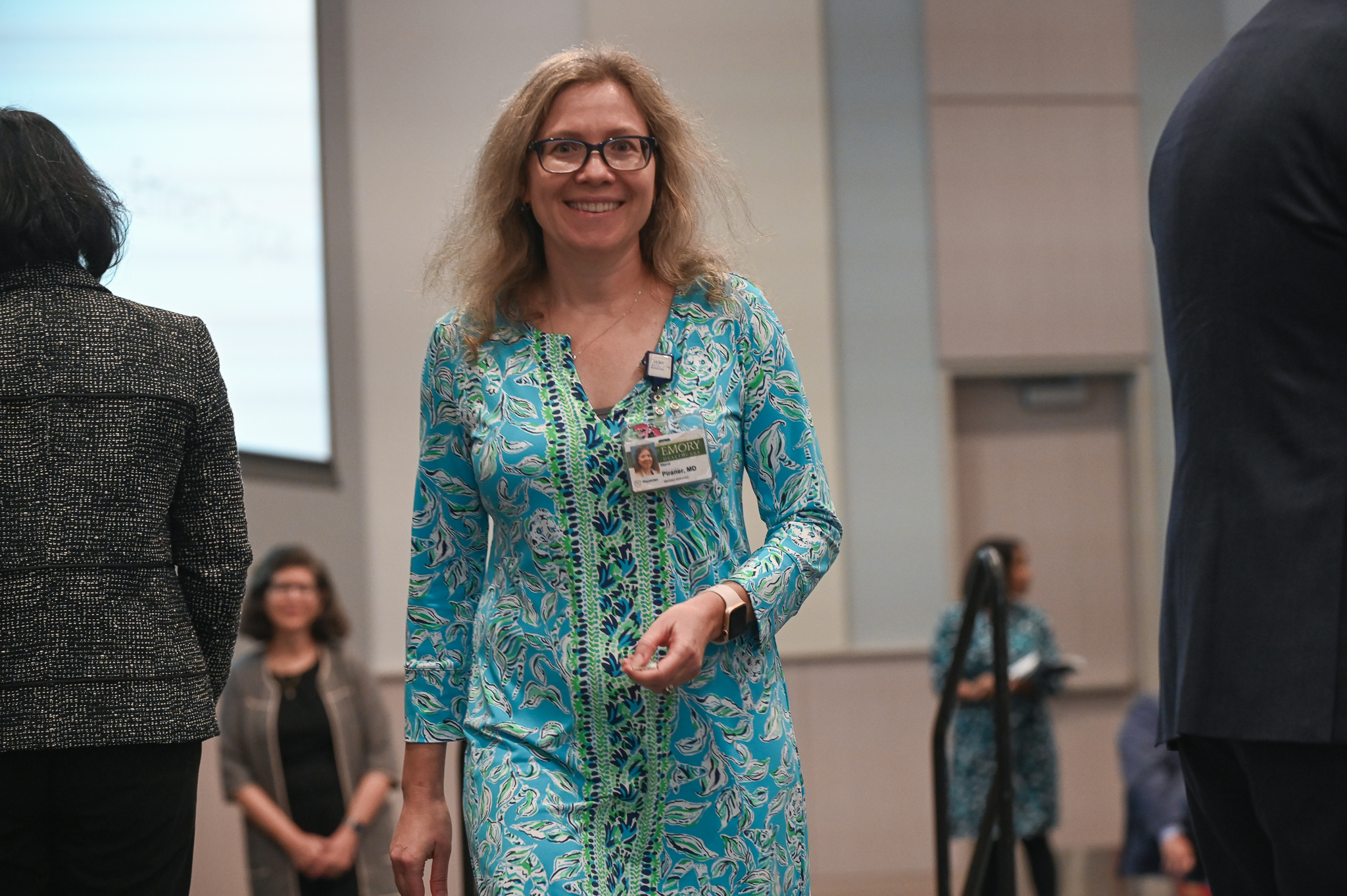 Faculty member smiles on stage after accepting award
