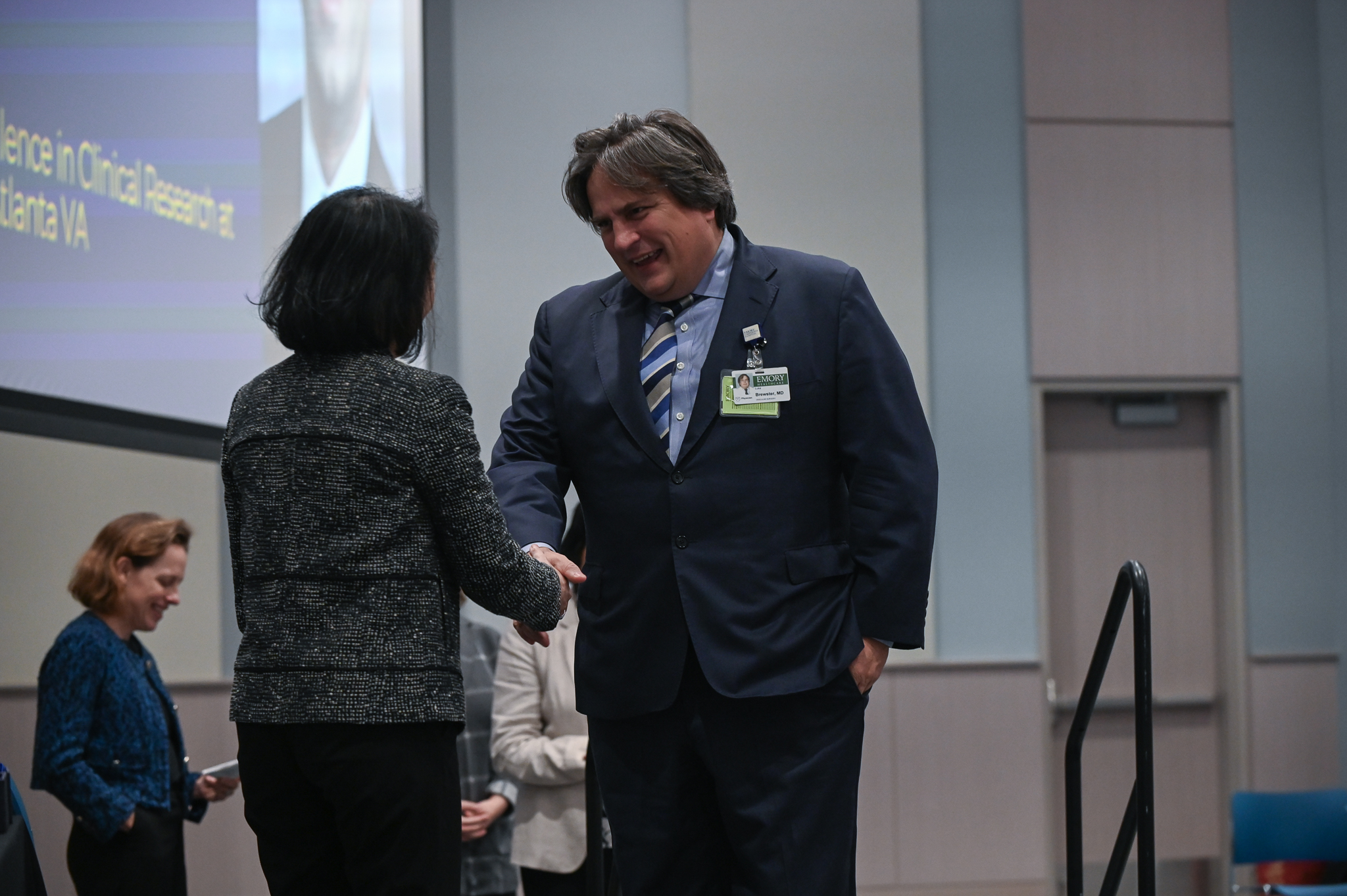 Faculty member accepts award on stage with dean