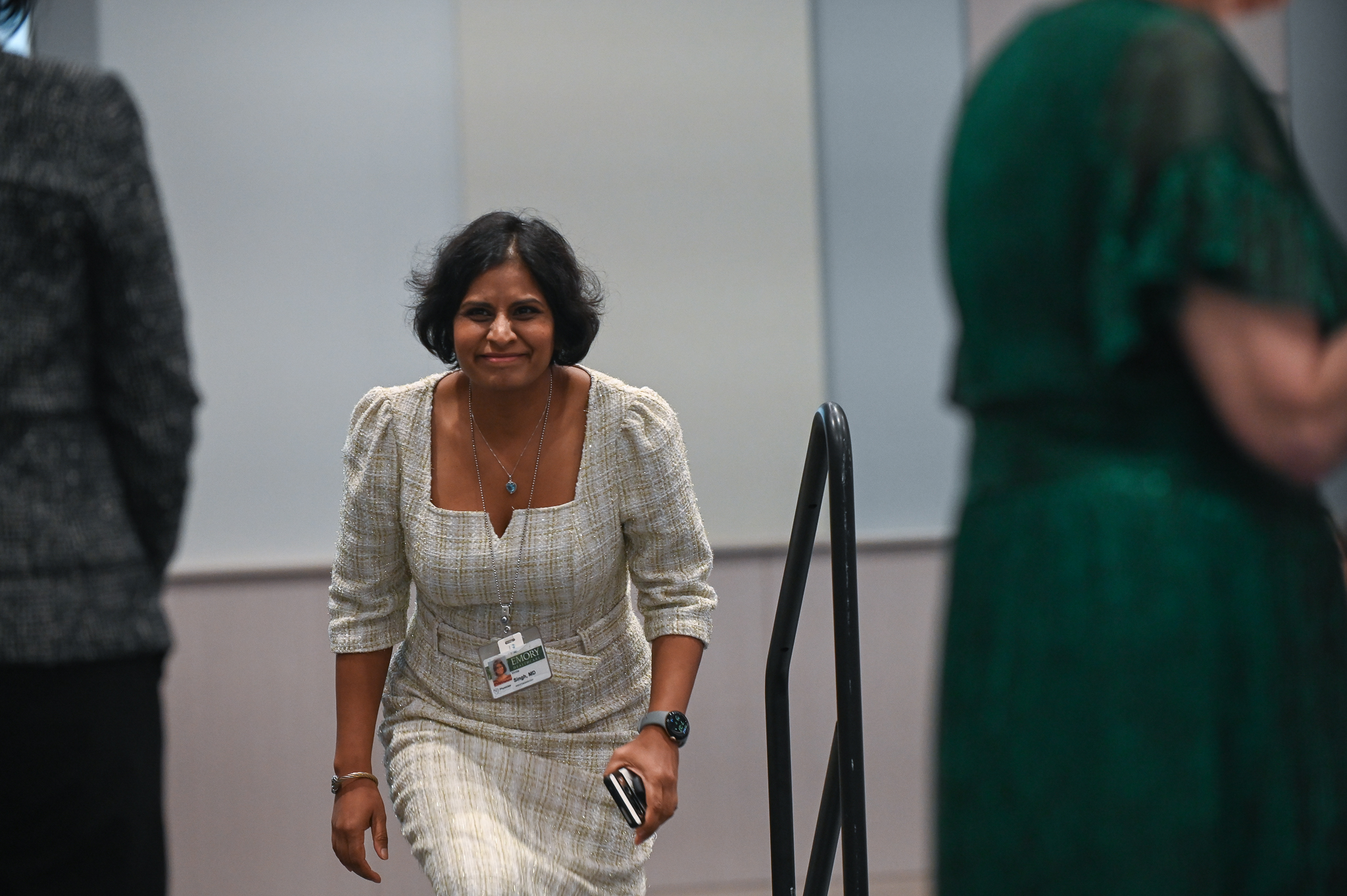 Faculty member smiles as she walks on stage to accept award