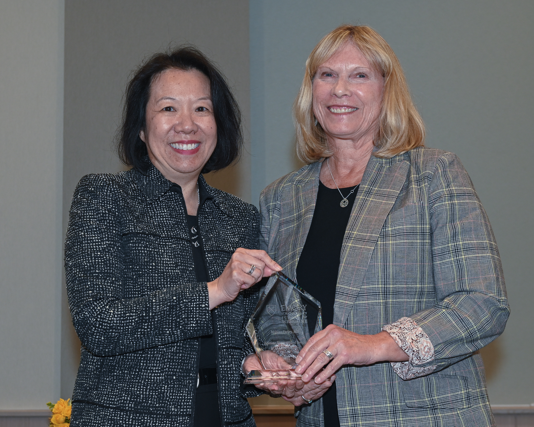 Faculty member accepts glass award on stage with dean
