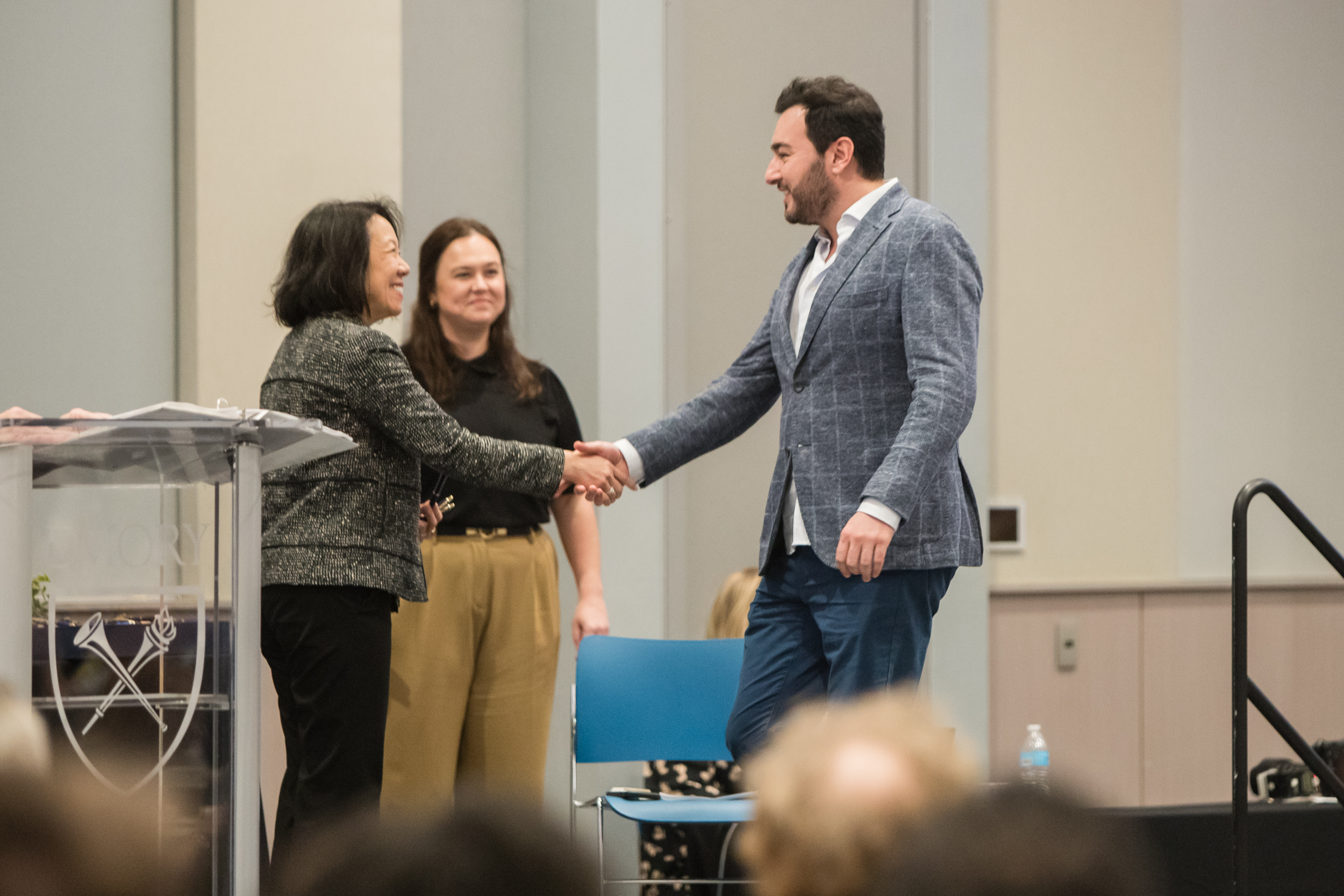 Faculty member accepts award on stage with dean