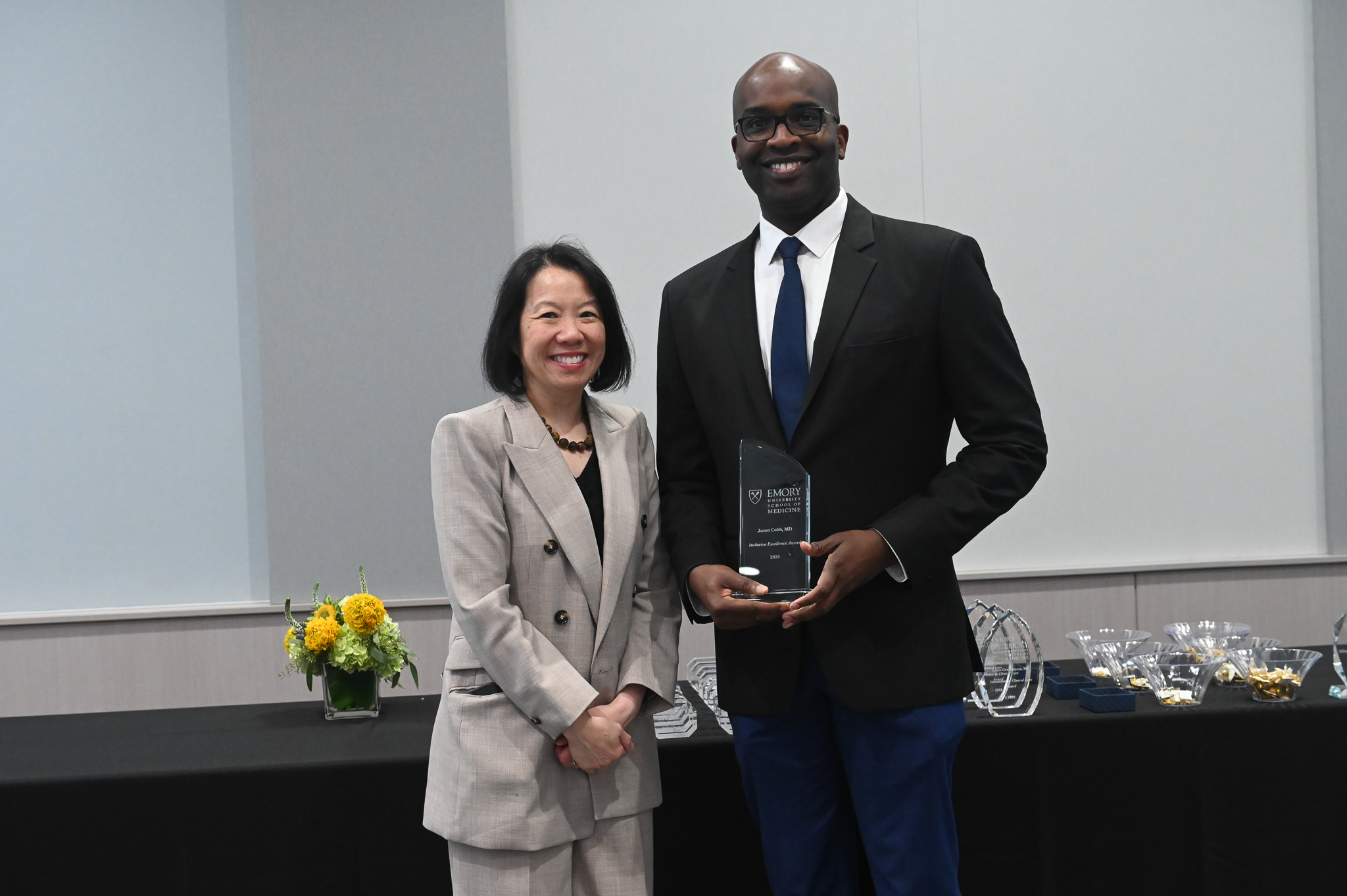 Faculty member accepts glass award on stage with dean