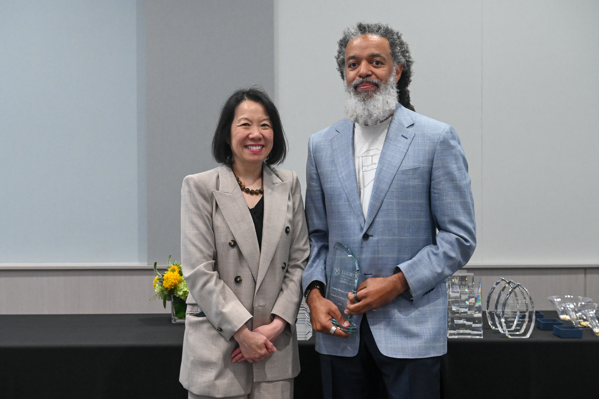Faculty member accepts glass award on stage with dean