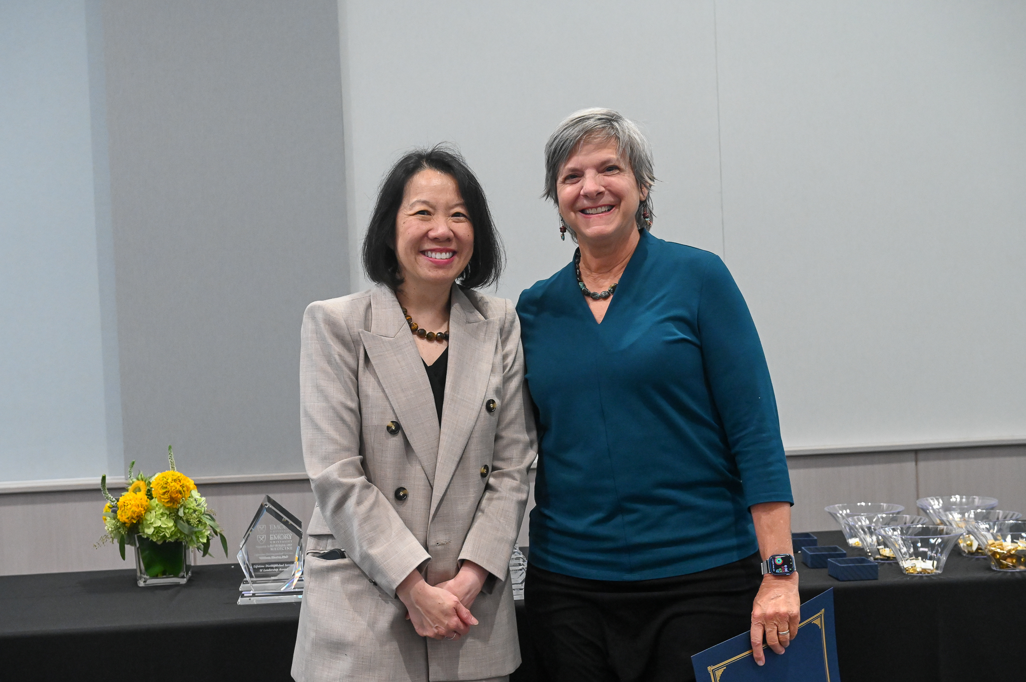 Faculty member smiles for a photo on stage with dean