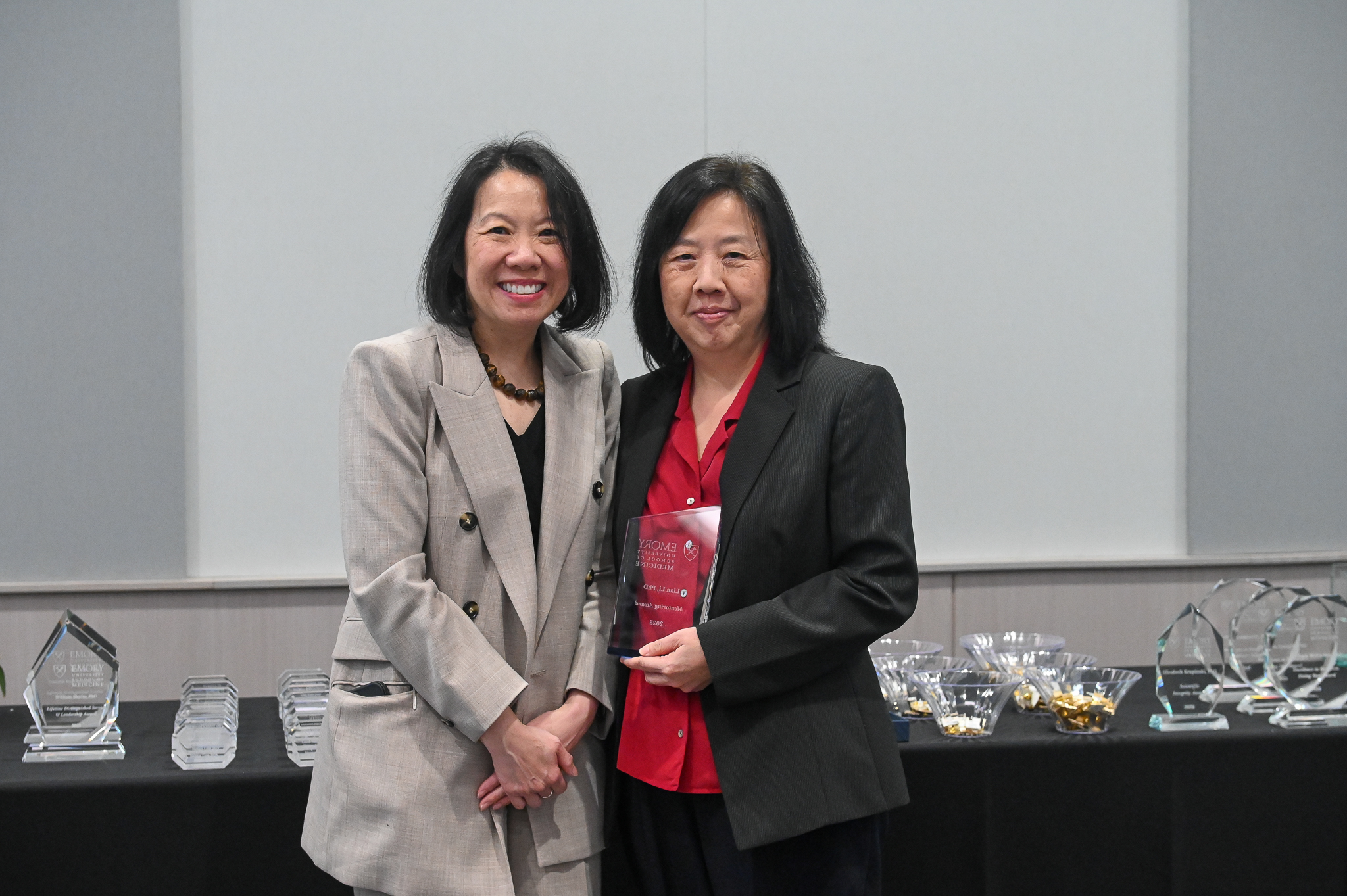 Faculty member accepts glass award on stage with dean