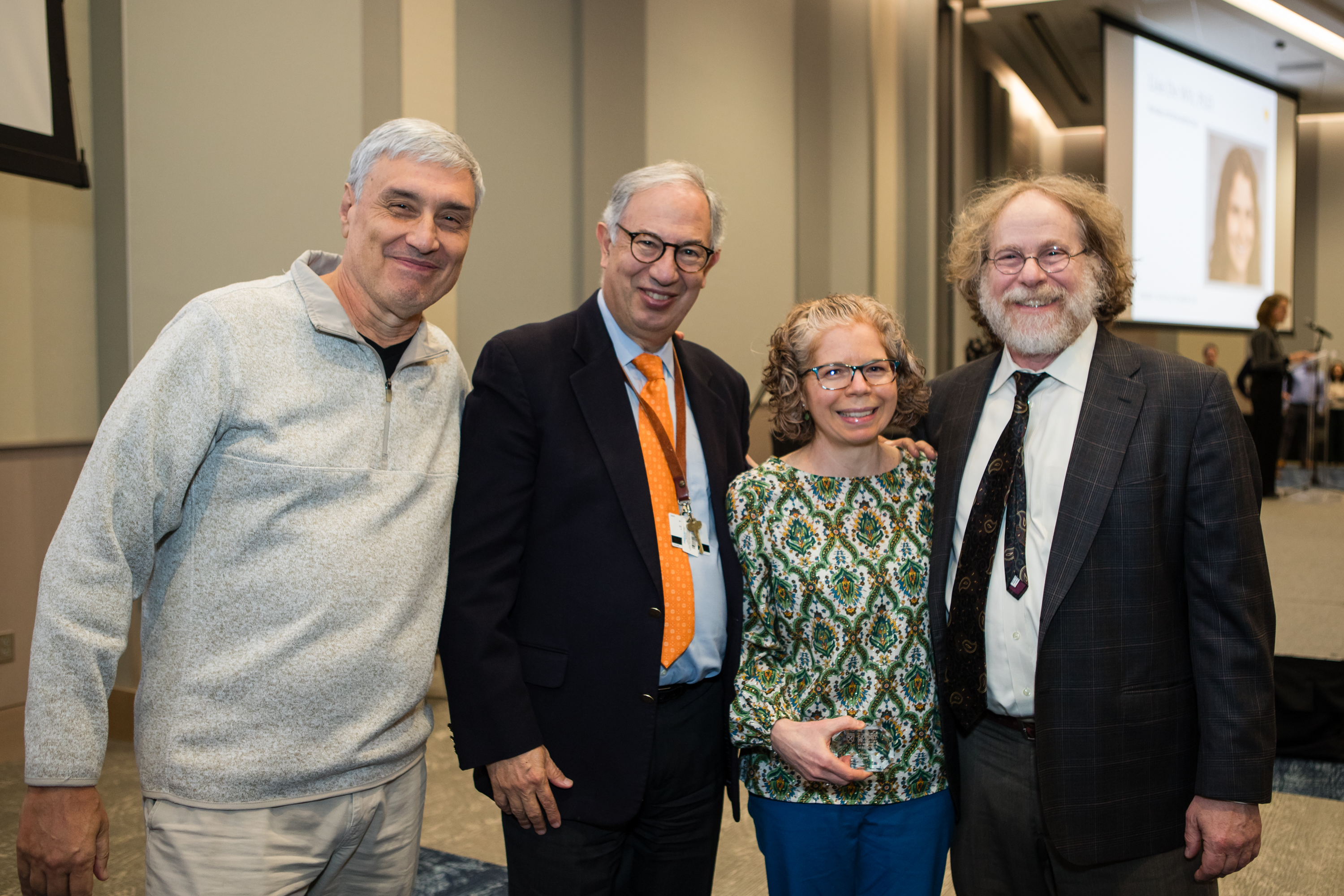 Four people smile for a group photo. 