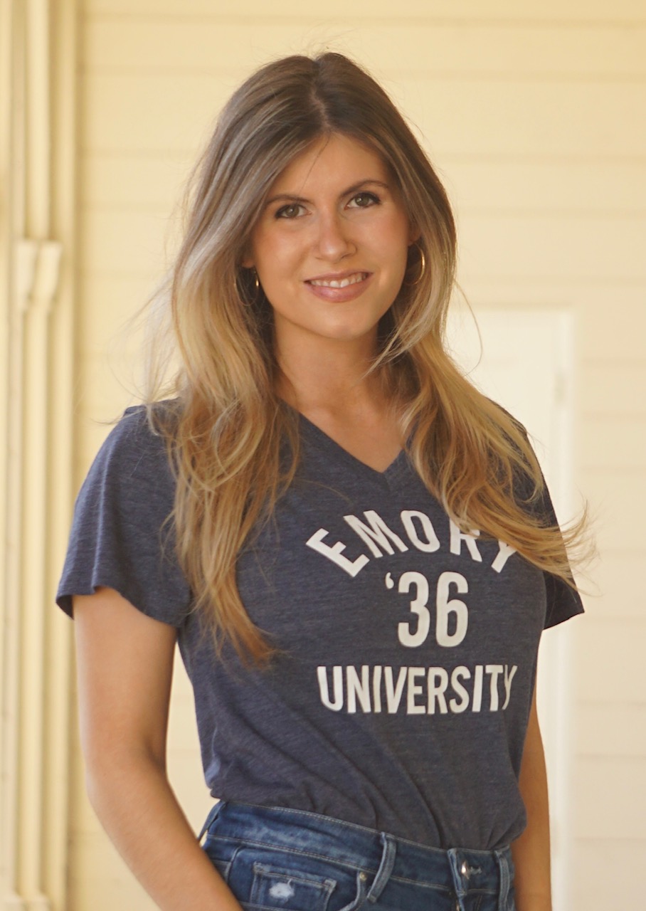 woman with long hear poses for a selfie while wearing an Emory t-shirt