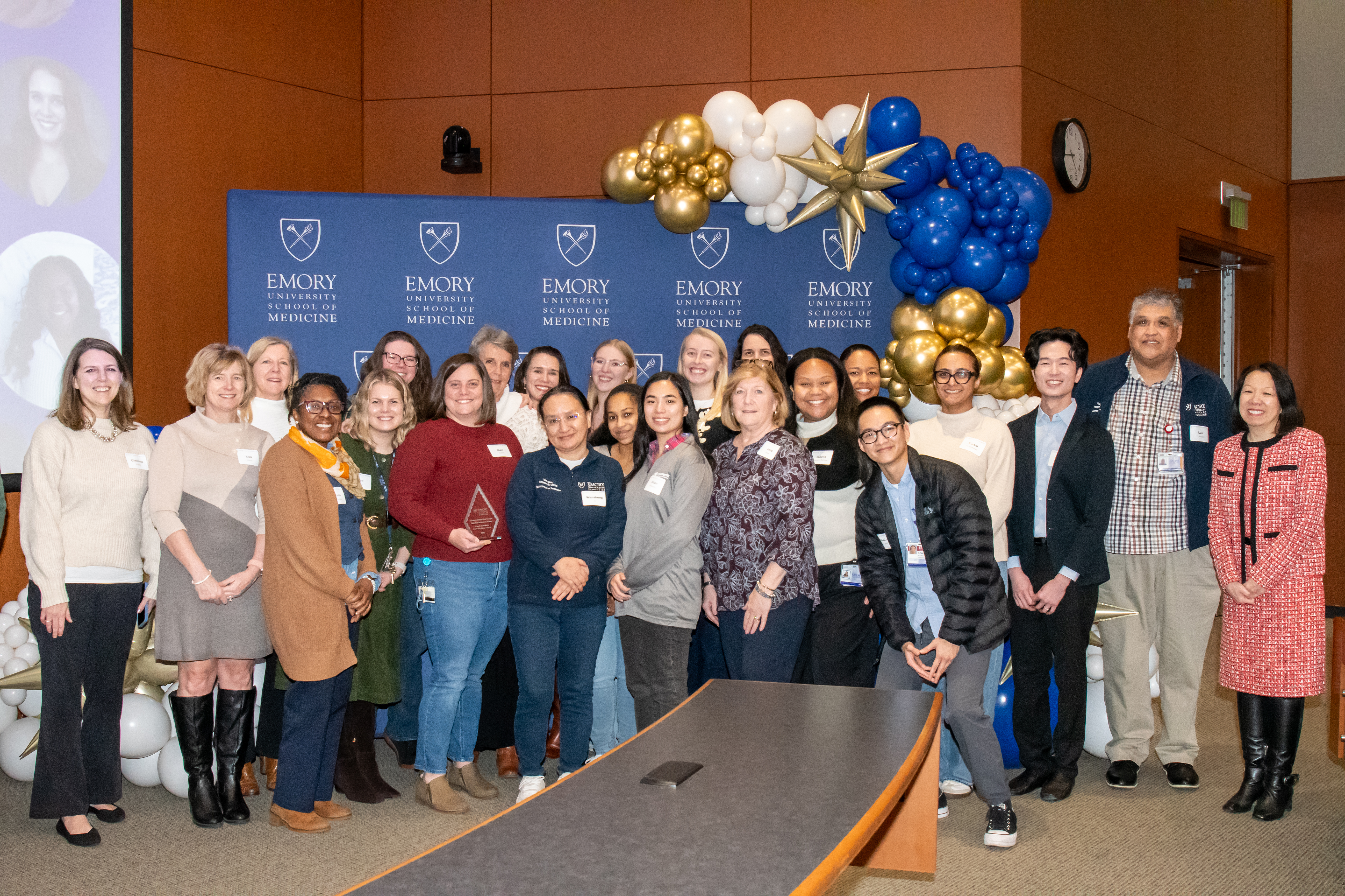 Emory Children's Center Vaccine Research Clinic team members smile for a group photo with their award.