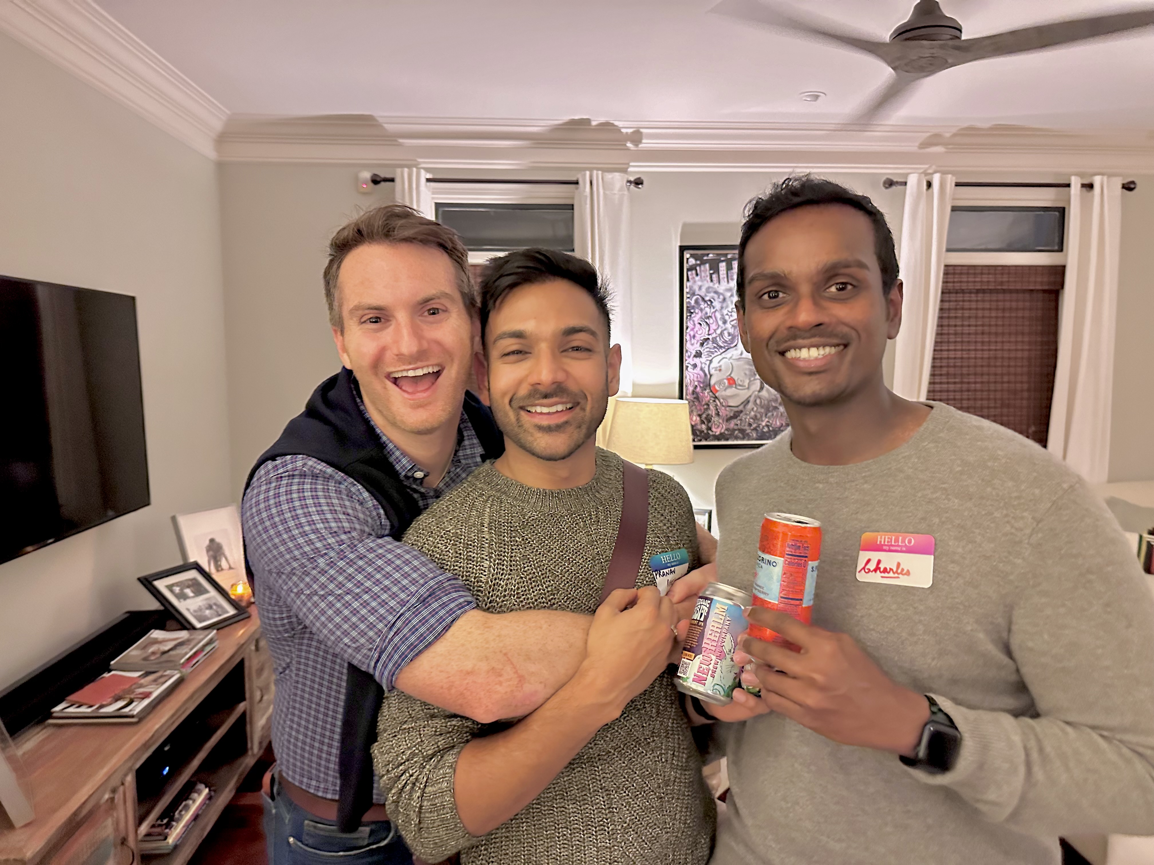 Three men smile for a photo together
