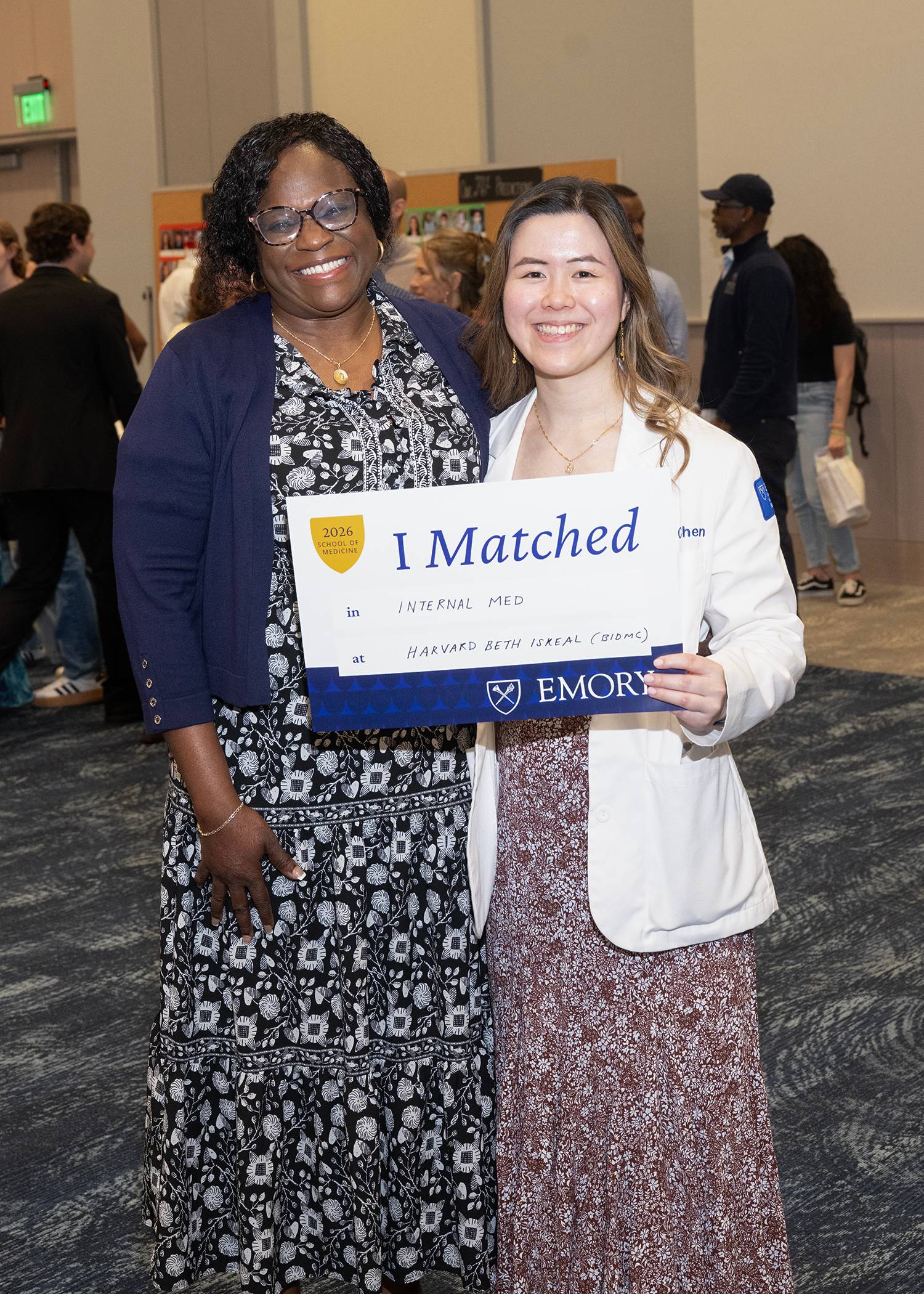 two women smiling one holding a sign that says I Matched
