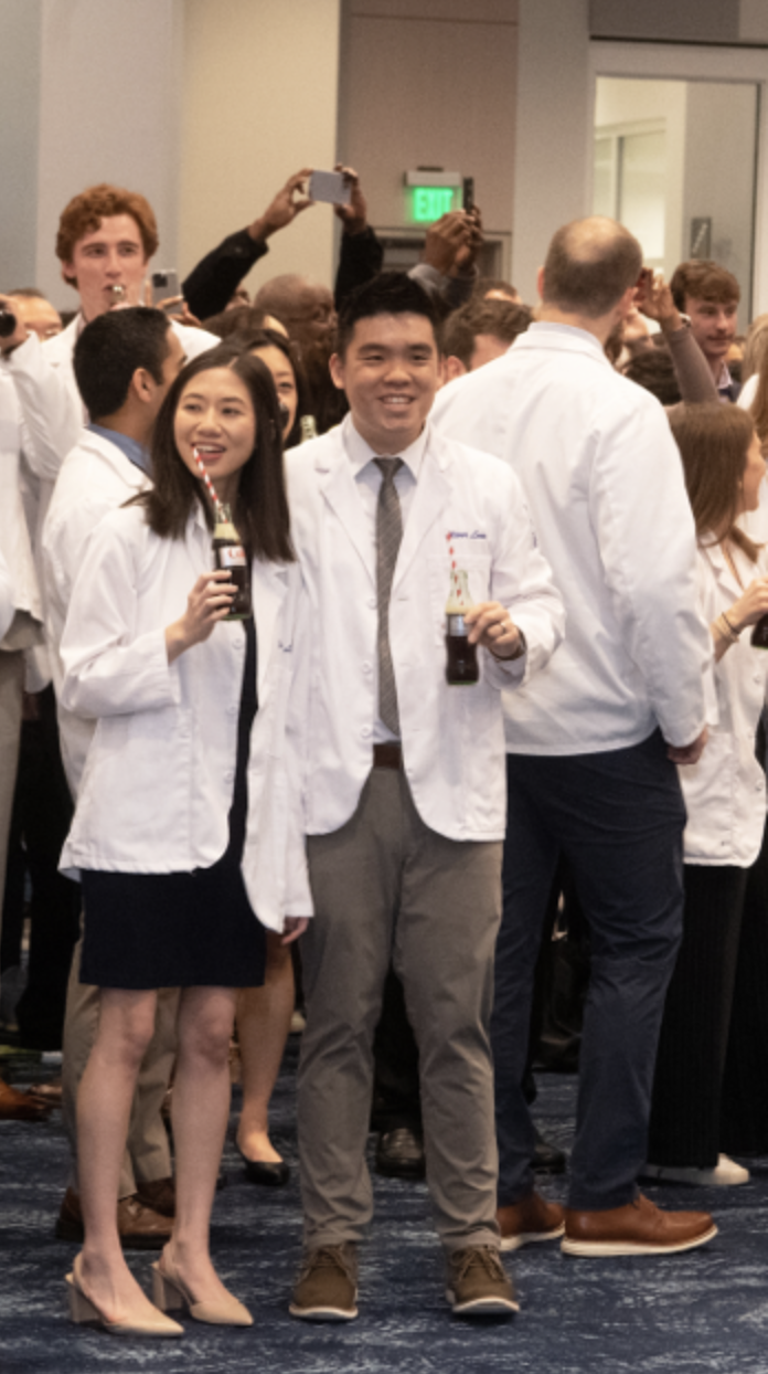 two people holding coke bottles in a crowd