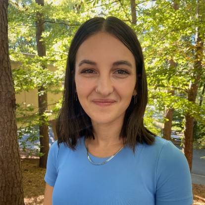 headshot of a young woman with dark hair wearing a blue shirt