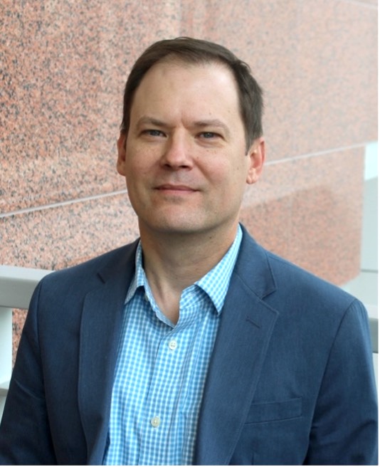 headshot of man in a blue sport coat