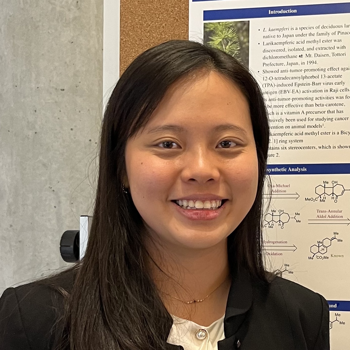 headshot of woman standing in front of bulletin board