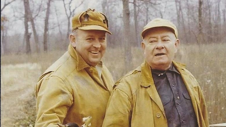 two men in tan jackets and hats