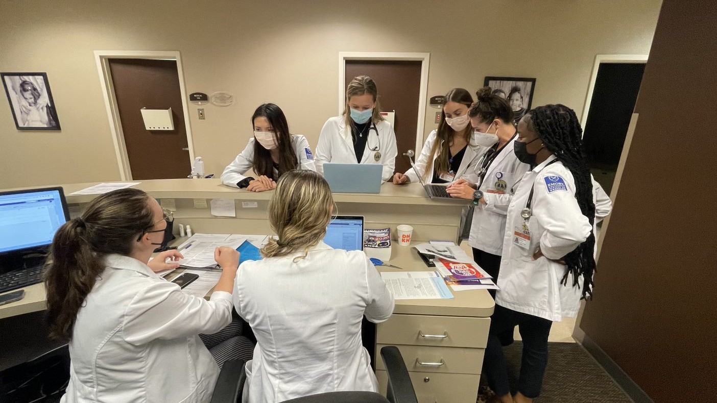 group of PA students gathered around a clinical workstation