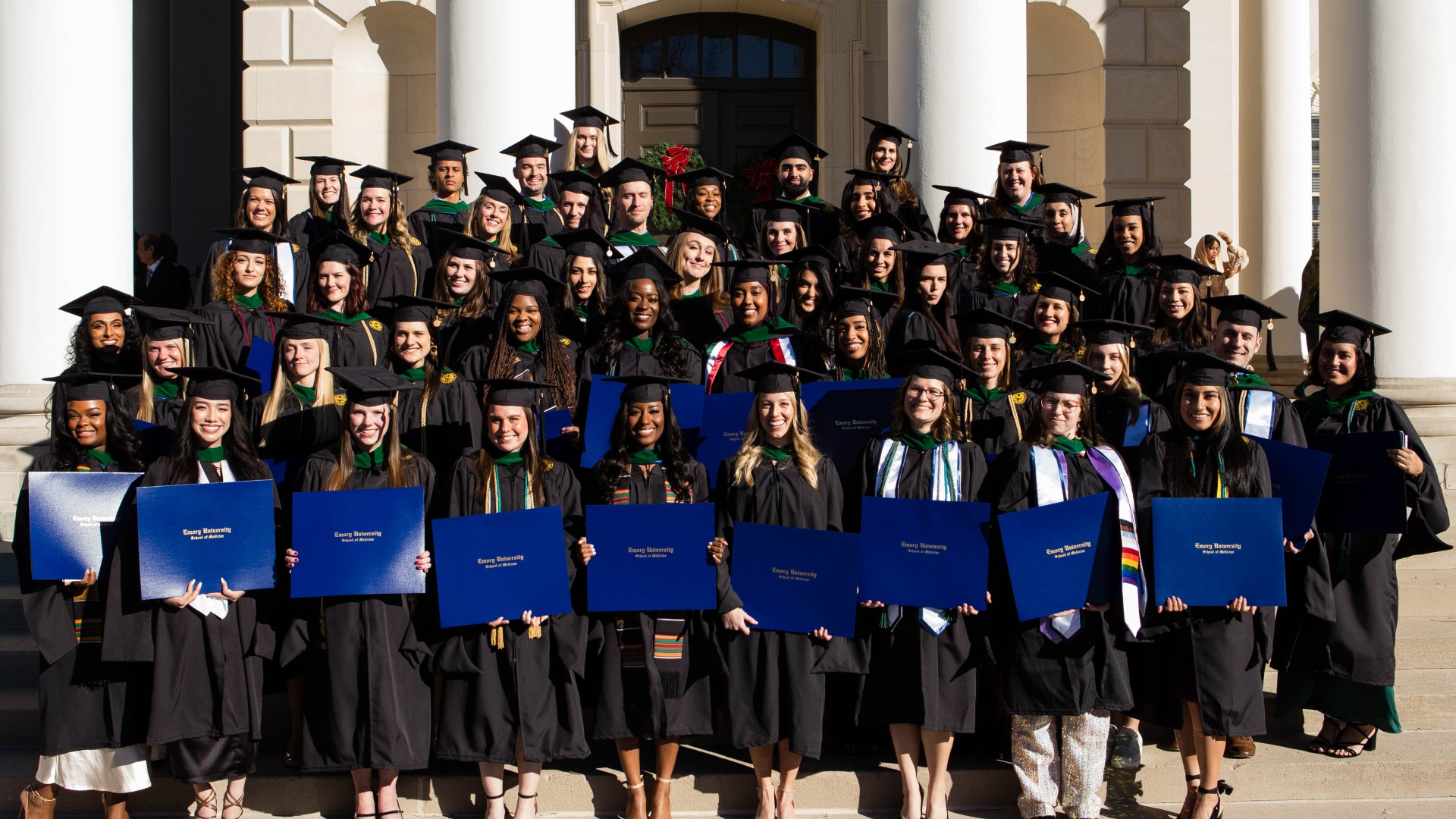 Emory PA Class of 2023 in caps and gowns, holding their diploma covers