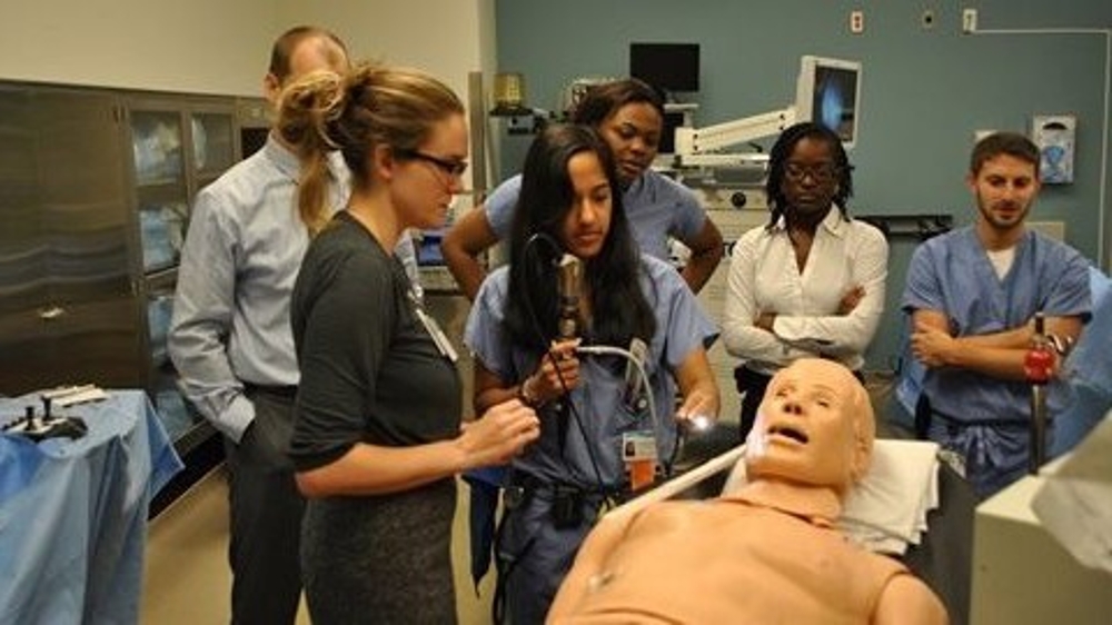 Physician Assistant students practicing a procedure on a dummy