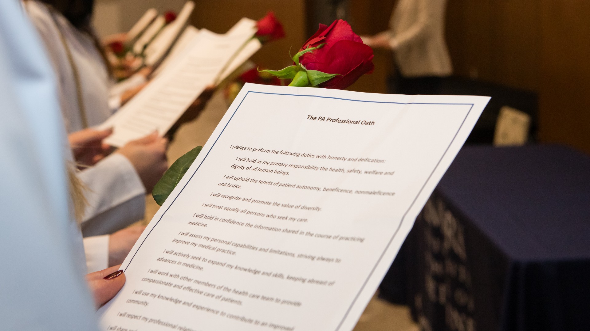 hand holding a sheet of paper with part of the PA Oath showing