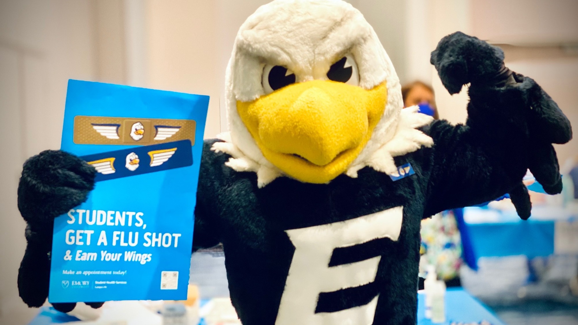 Swoop the Emory holding a flu vaccine promotion sign
