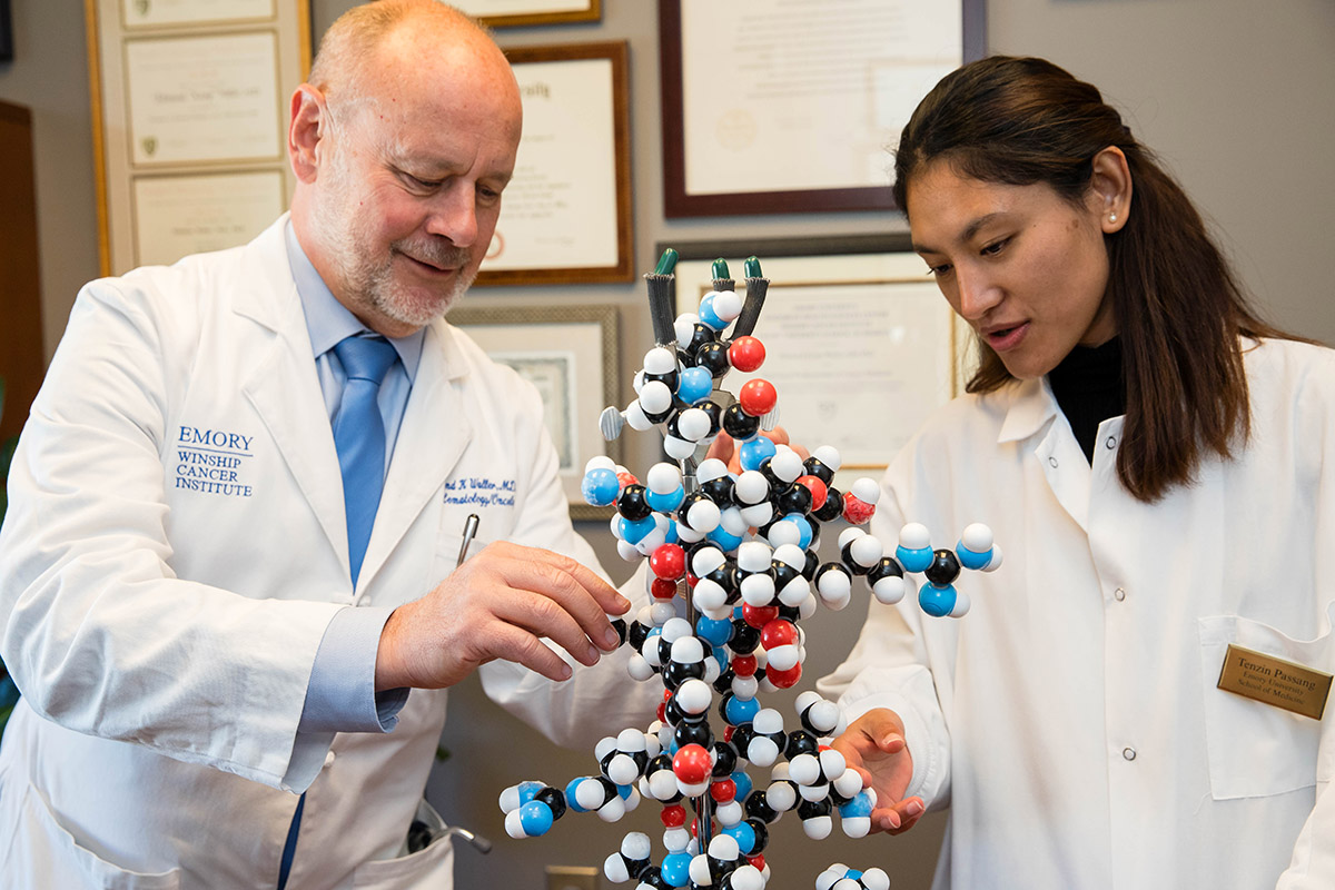 Dr. Ned Waller and Tenzin Kalsang with a DNA model.