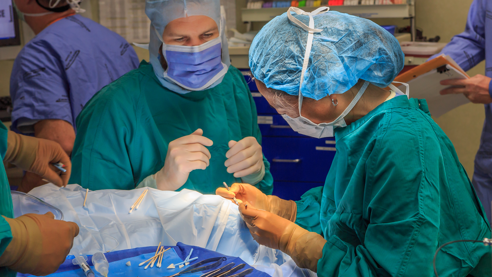 Surgeons performing retina surgery, fully masked
