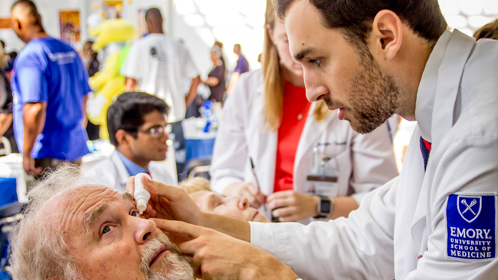 a GO-E doctor performing an eye exam on a male patient at a GO-E clinic in Georgia