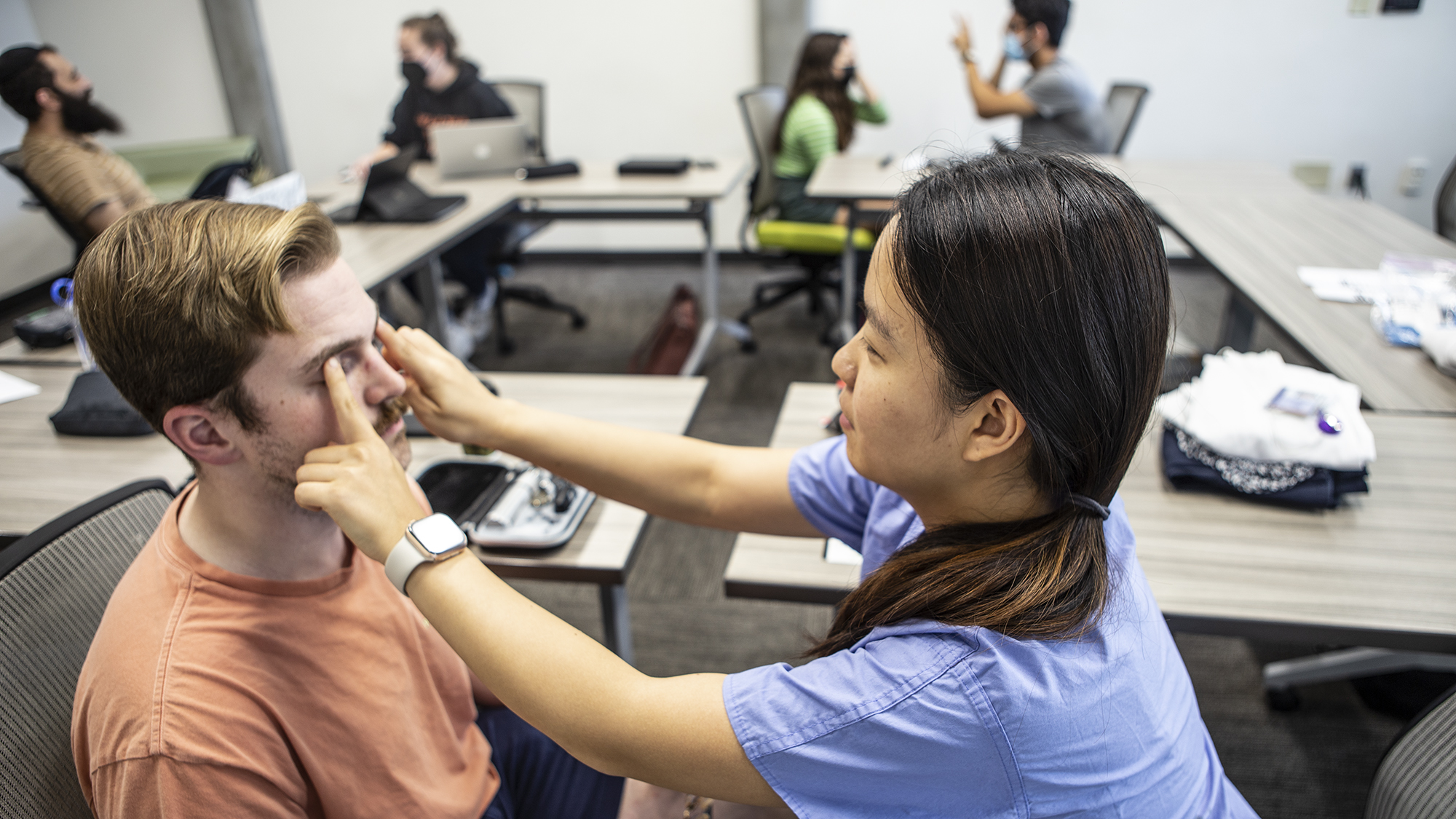 two medical students participate in an introductory traininig on eye exams