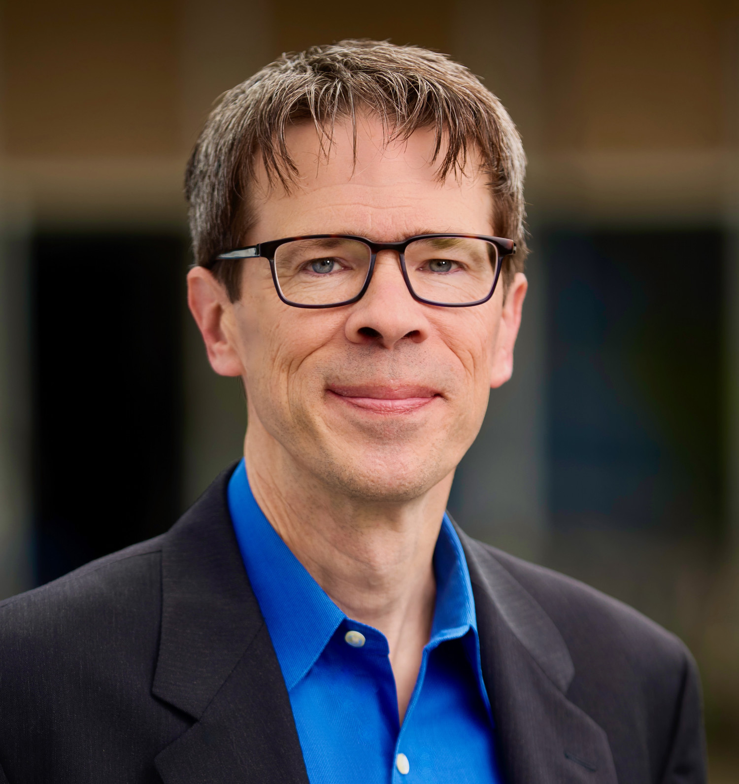 heahshot of man in suit with blue shirt