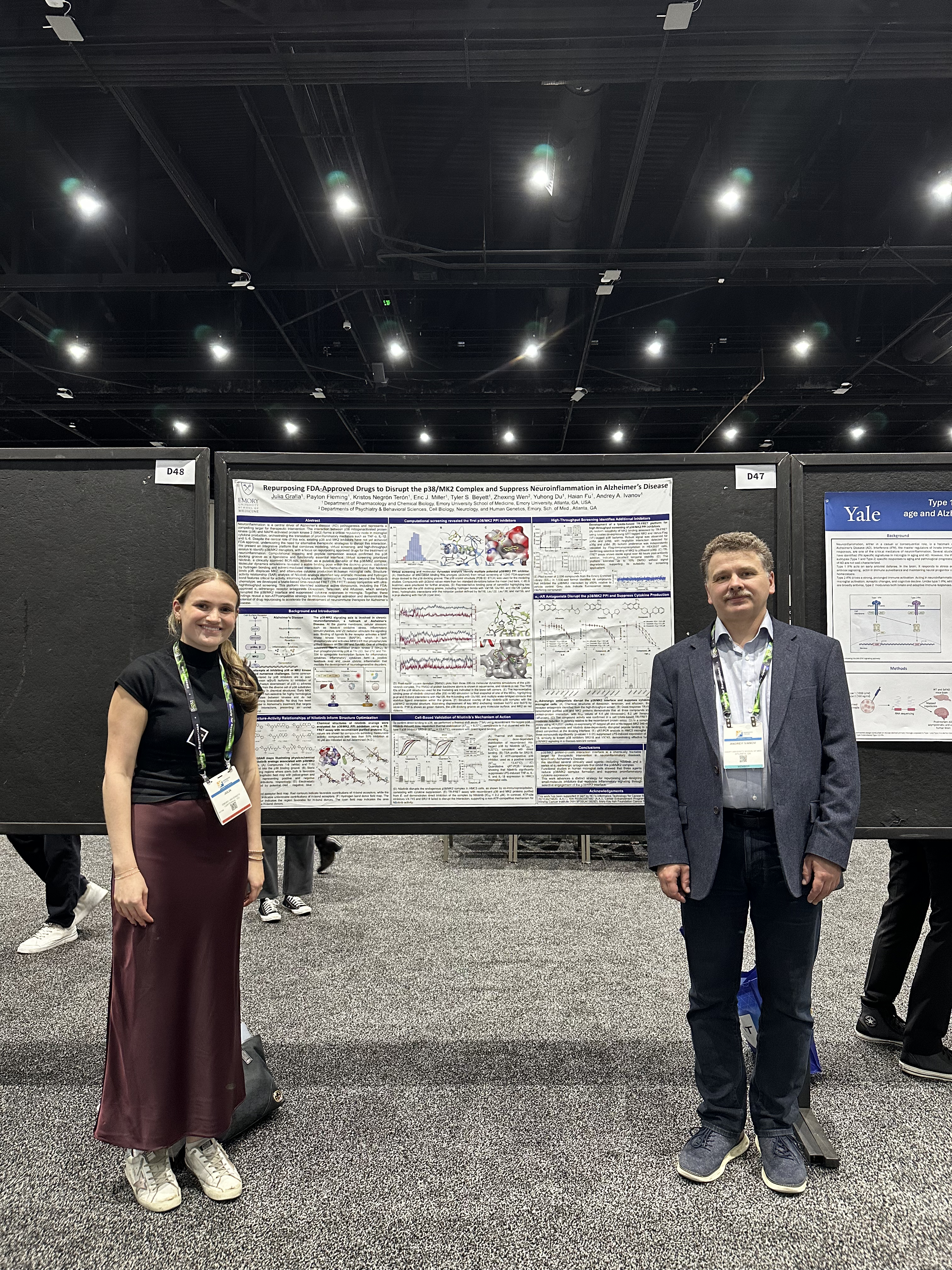 man and woman standing in front of poster presentation on board