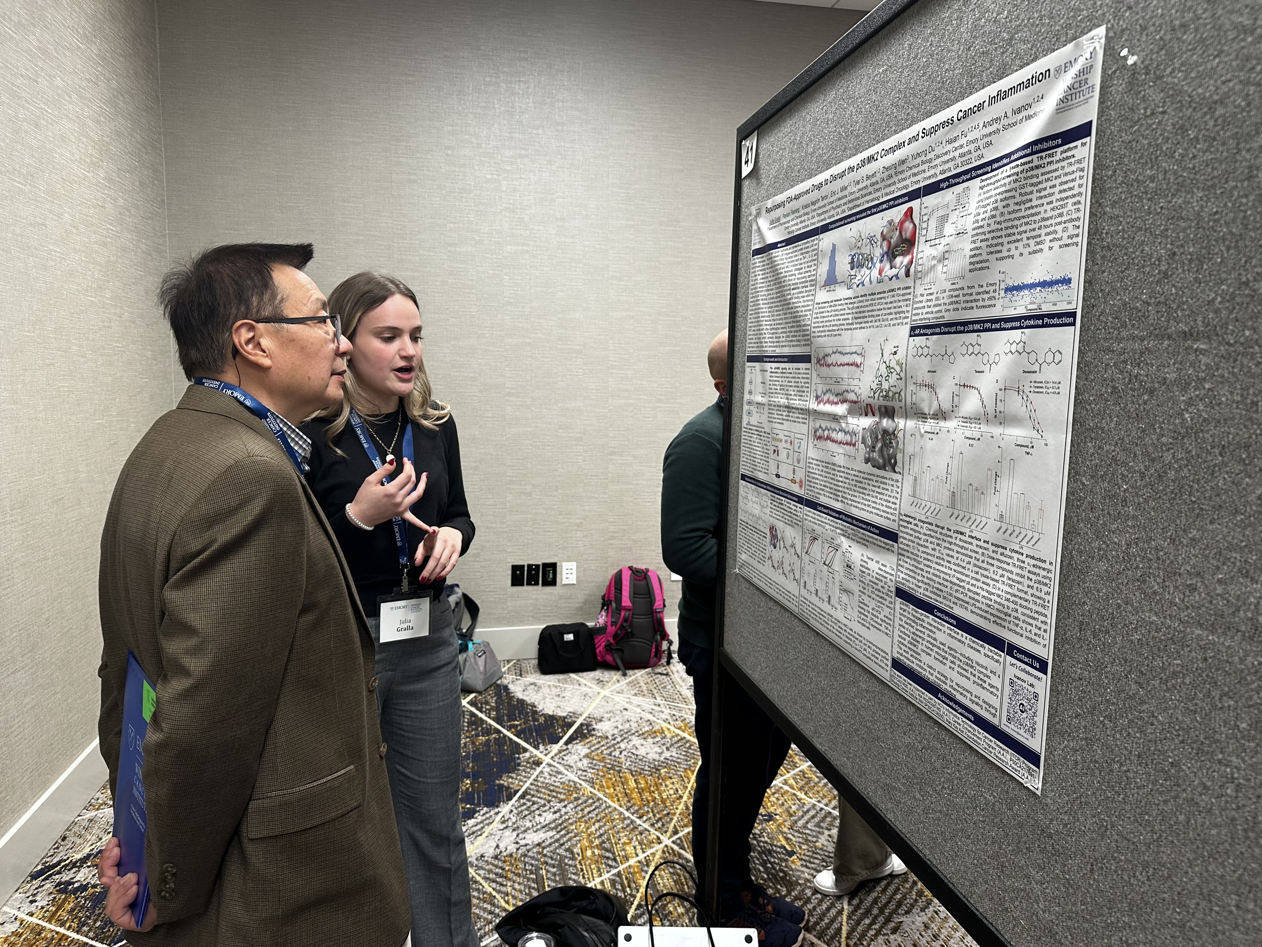 man and woman standing at poster presentation board