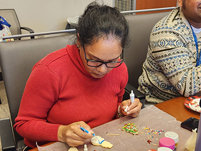 Suneela decorates a holiday cookie.