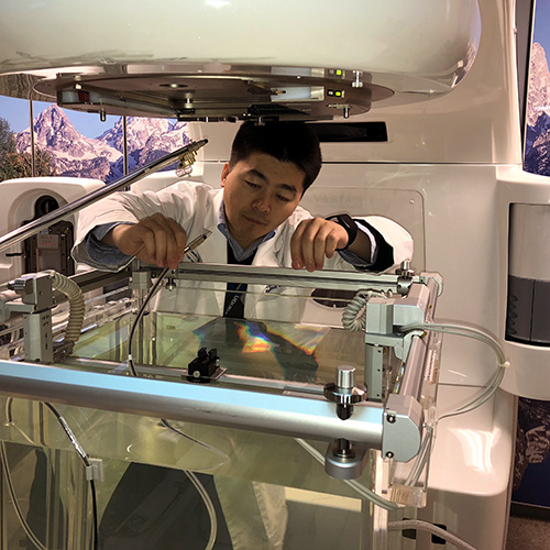 Medical physicist Xiaofeng Yang, PhD working on an imaging scanner.