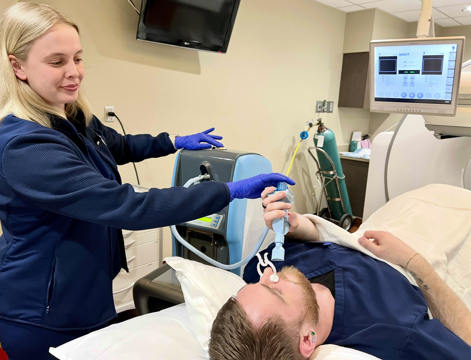technologist administering an inhaled medication to patient