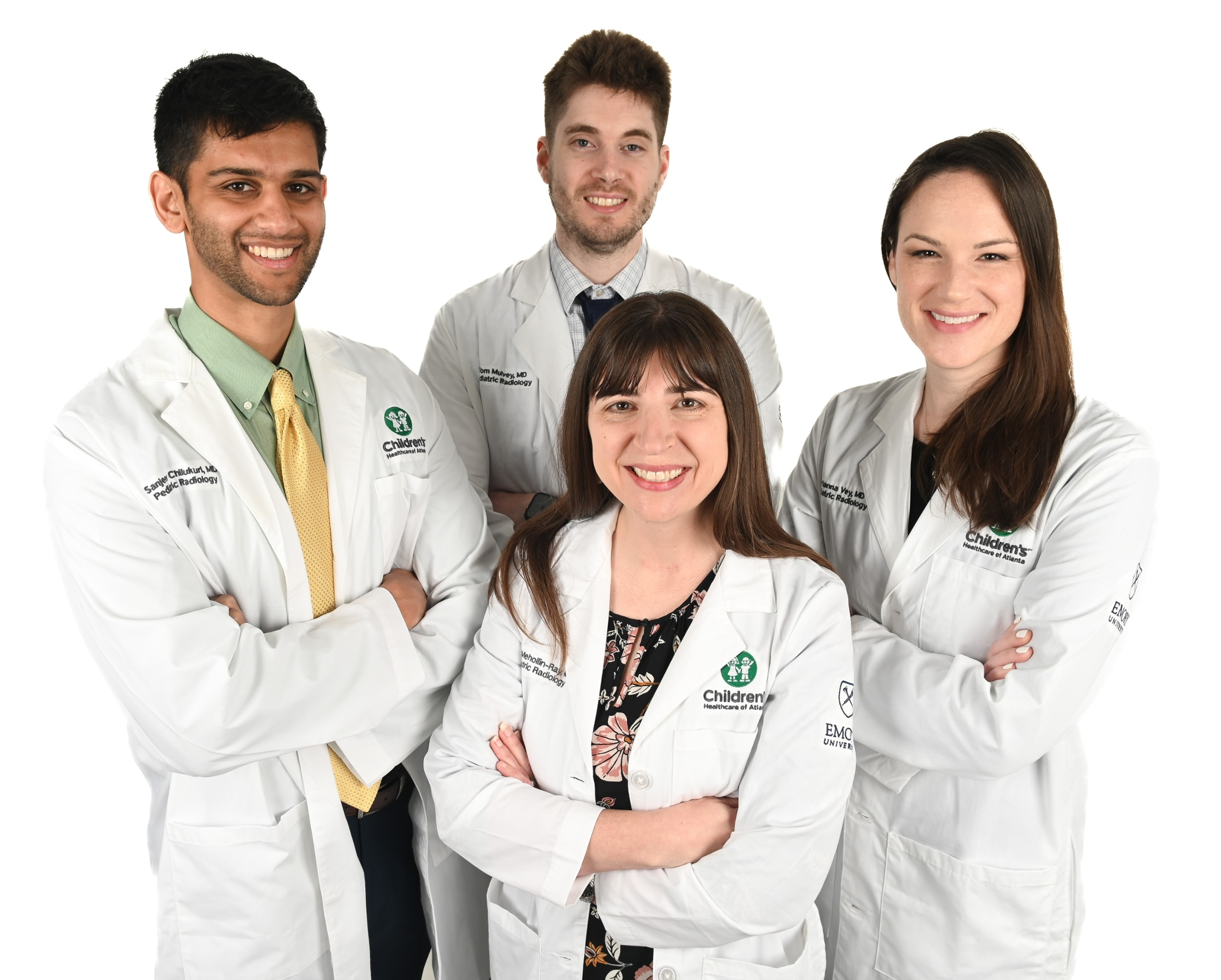 4 smiling people wearing white doctor coats with their arms crossed in front of themselves