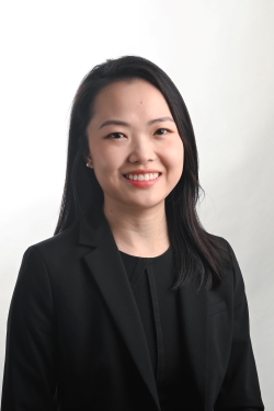 smiling woman with straight black hair wearing a black suit jacket over a black top