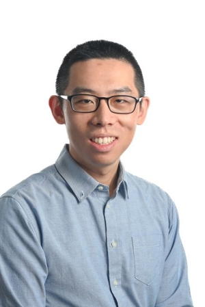 smiling person wearing spectacles and a blue button down shirt