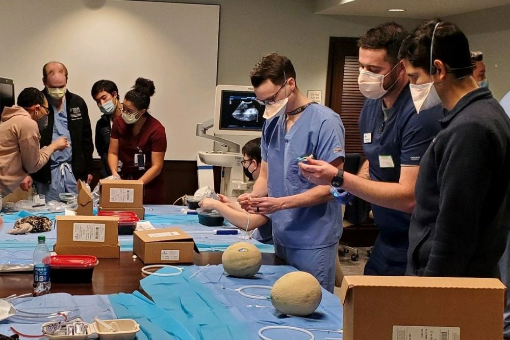 people wearing surgical masks and scrubs performing practice procedures