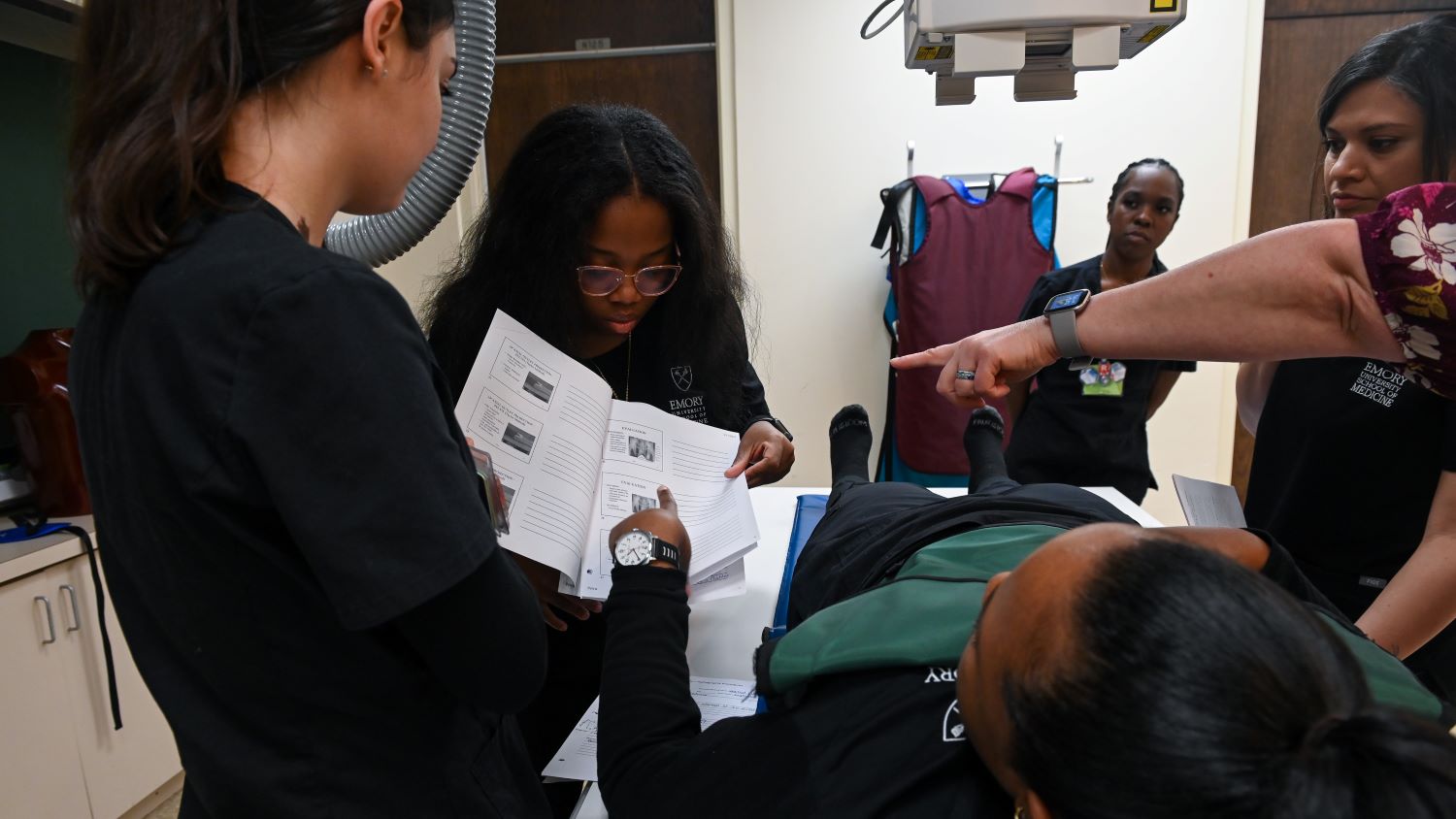 students looking at instructions while learning to position a patient for xray
