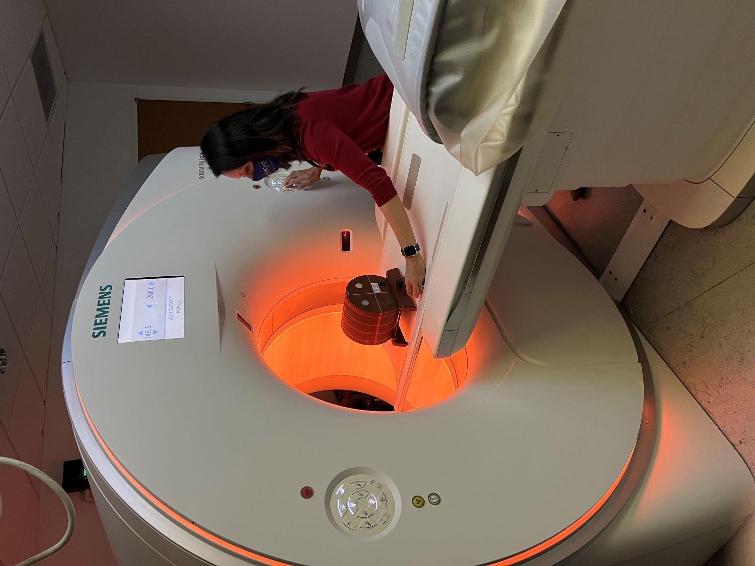 person testing a CT machine which has glowing lights