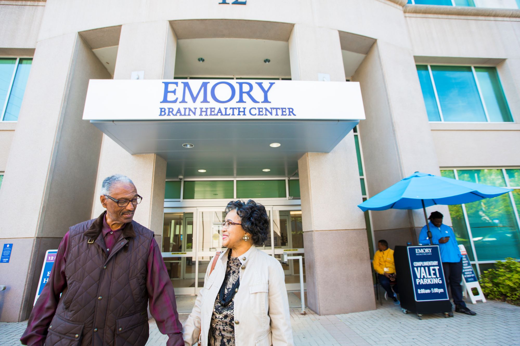 two people standing outside a concrete and glass building that says Emory Brain Health Center
