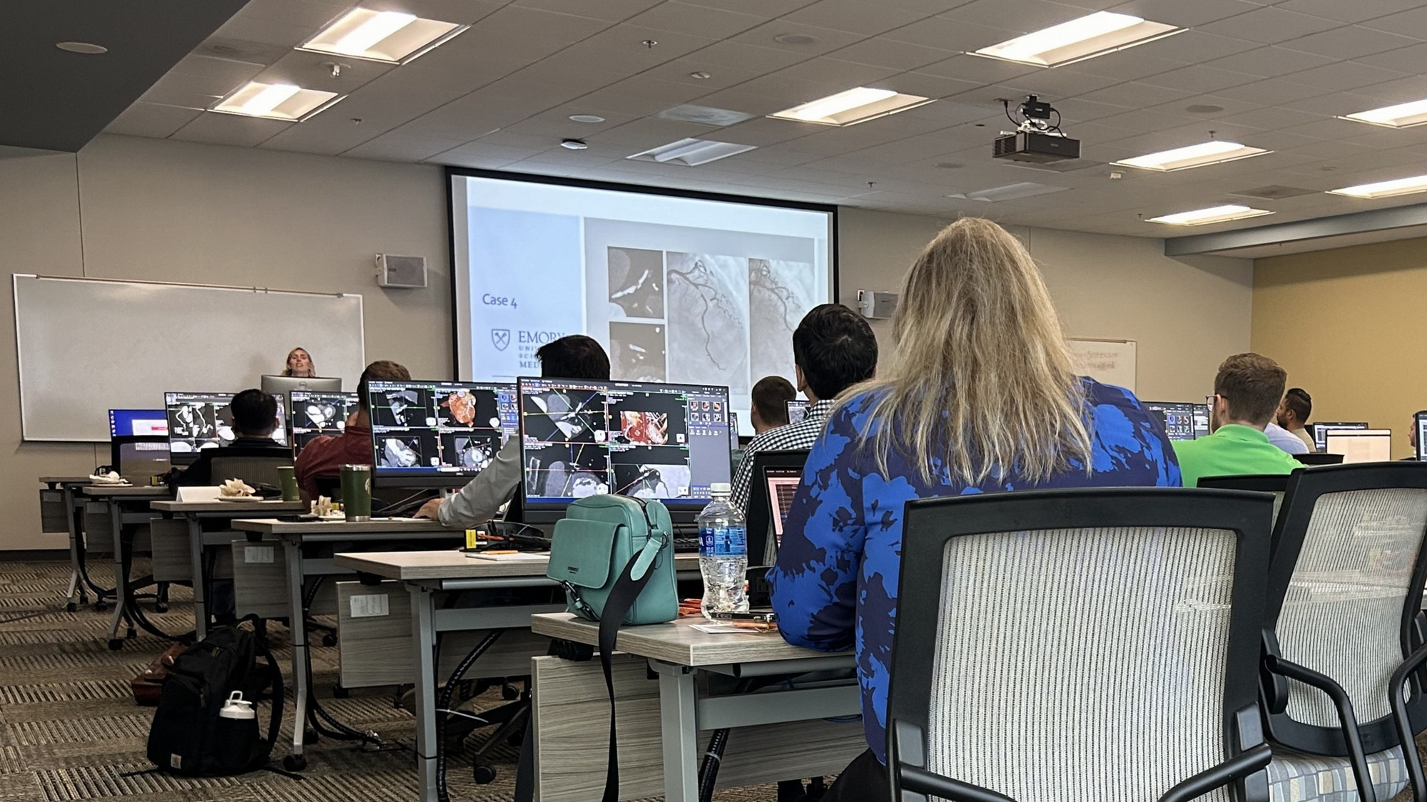 classroom with people working at computer workstations with images from cardiac CT cases visible on their screens