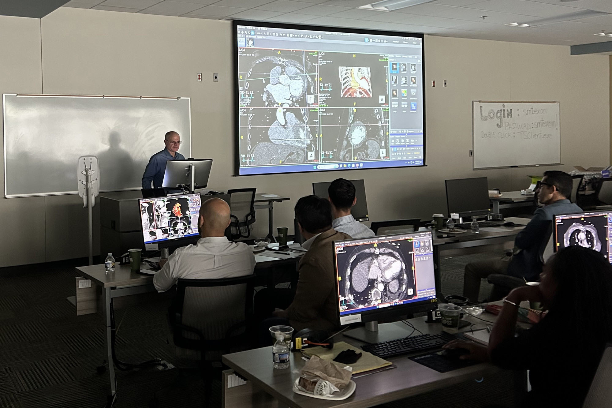 instructor at front of classroom showing cardiac imaging case to class